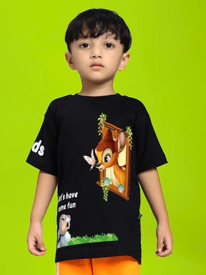 Child wearing BAMBI TOON T-SHIRT FOR BOYS AND GIRLS BLACK with Bambi and Thumper design on a bright green background.