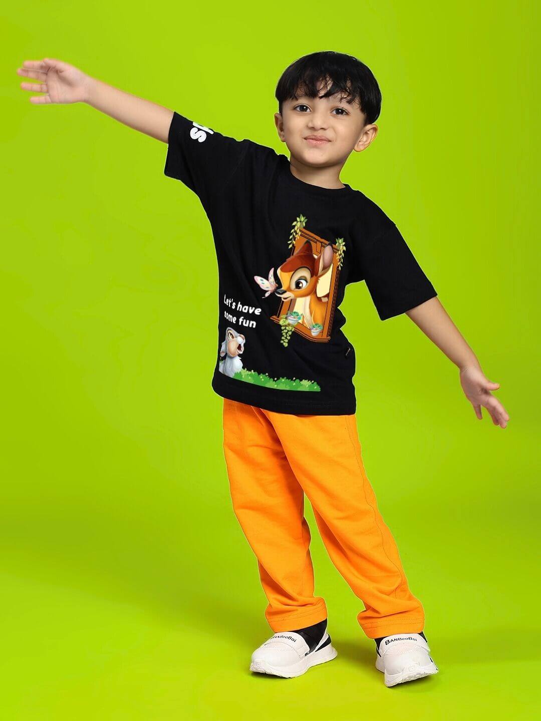 Child wearing BAMBI TOON T-SHIRT FOR BOYS AND GIRLS BLACK with cartoon on green background