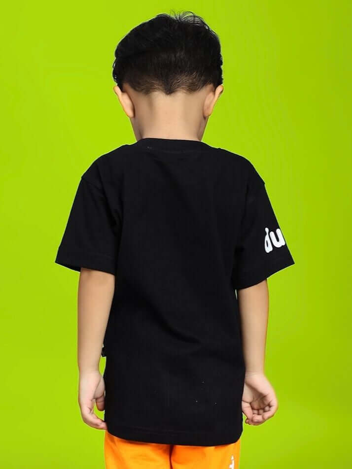Back view of child wearing BAMBI TOON T-SHIRT FOR BOYS AND GIRLS BLACK, green background highlighting the tee's design.