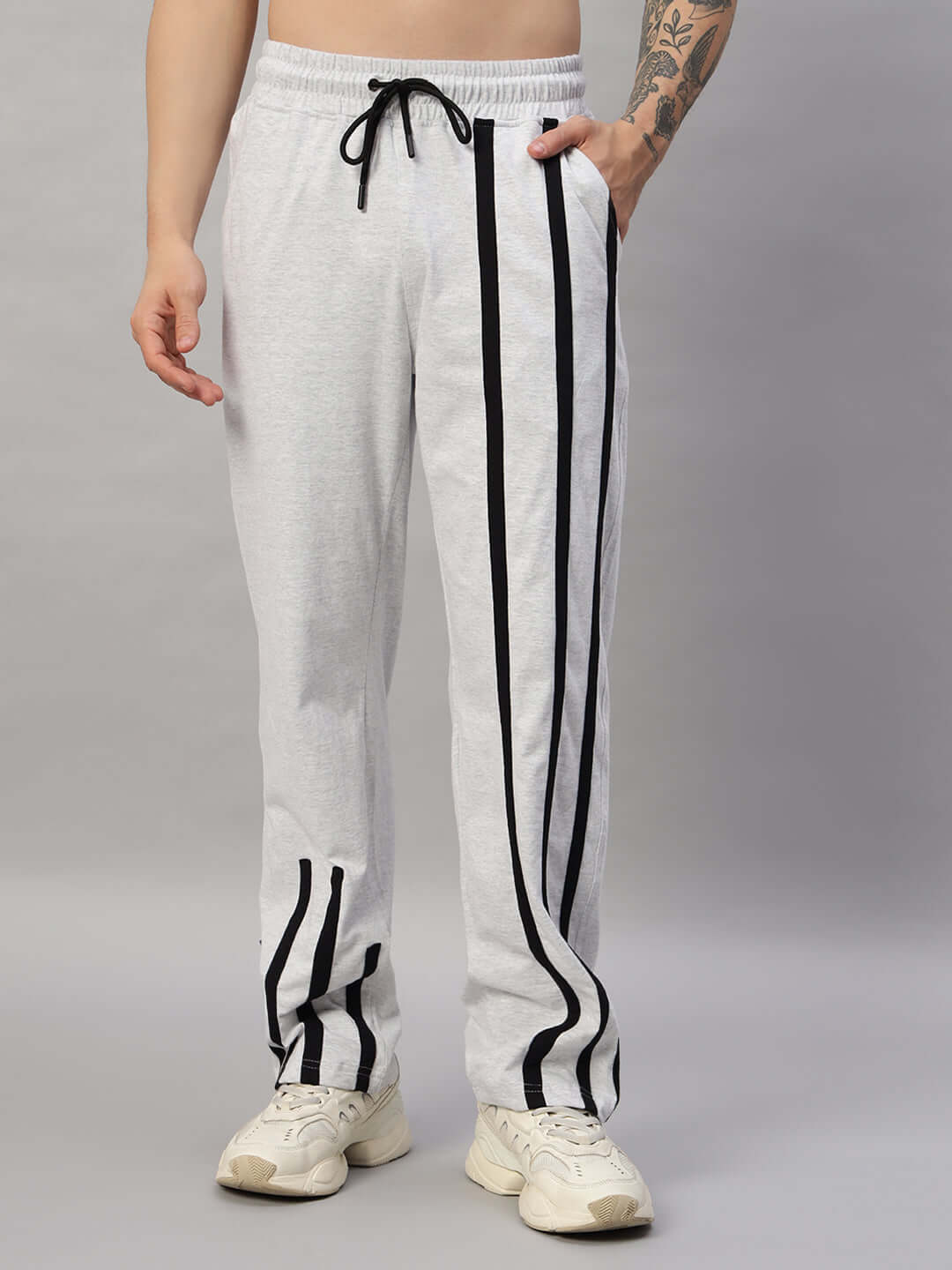 Model wearing BASTILLE OVERSIZED CO-ORD SET MELANGE GREY featuring relaxed fit pants with black stripes.