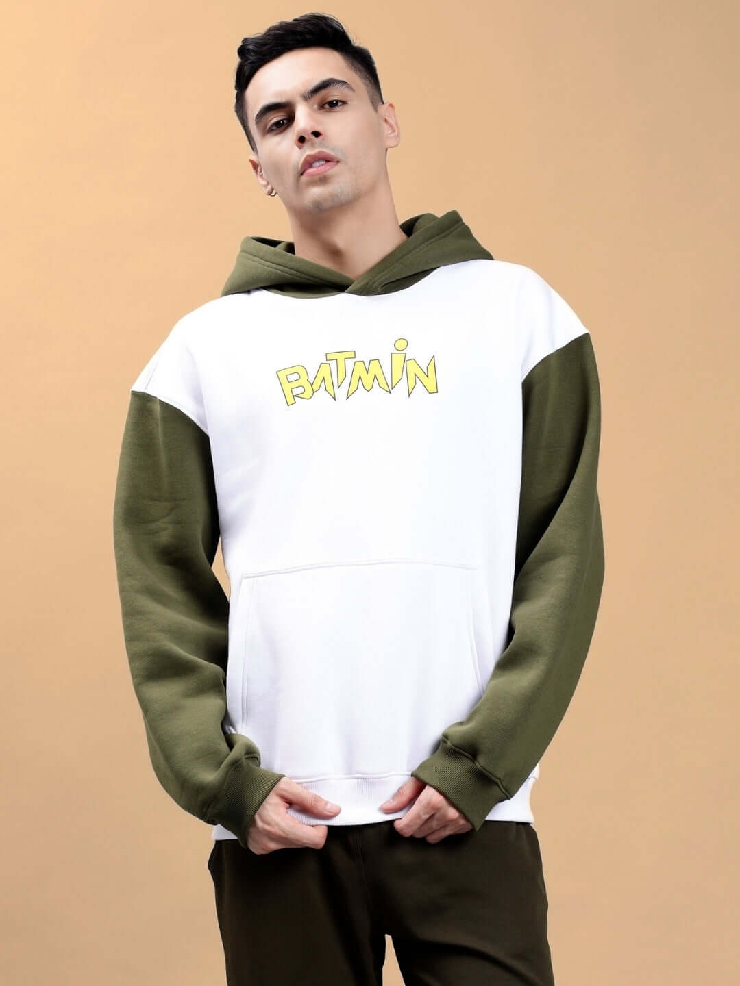 Man wearing BATMIN COLORBLOCK OVERSIZED FLEECE HOODIE WHITE-OLIVE GREEN, showcasing a streetwear style with a bold colorblock design.