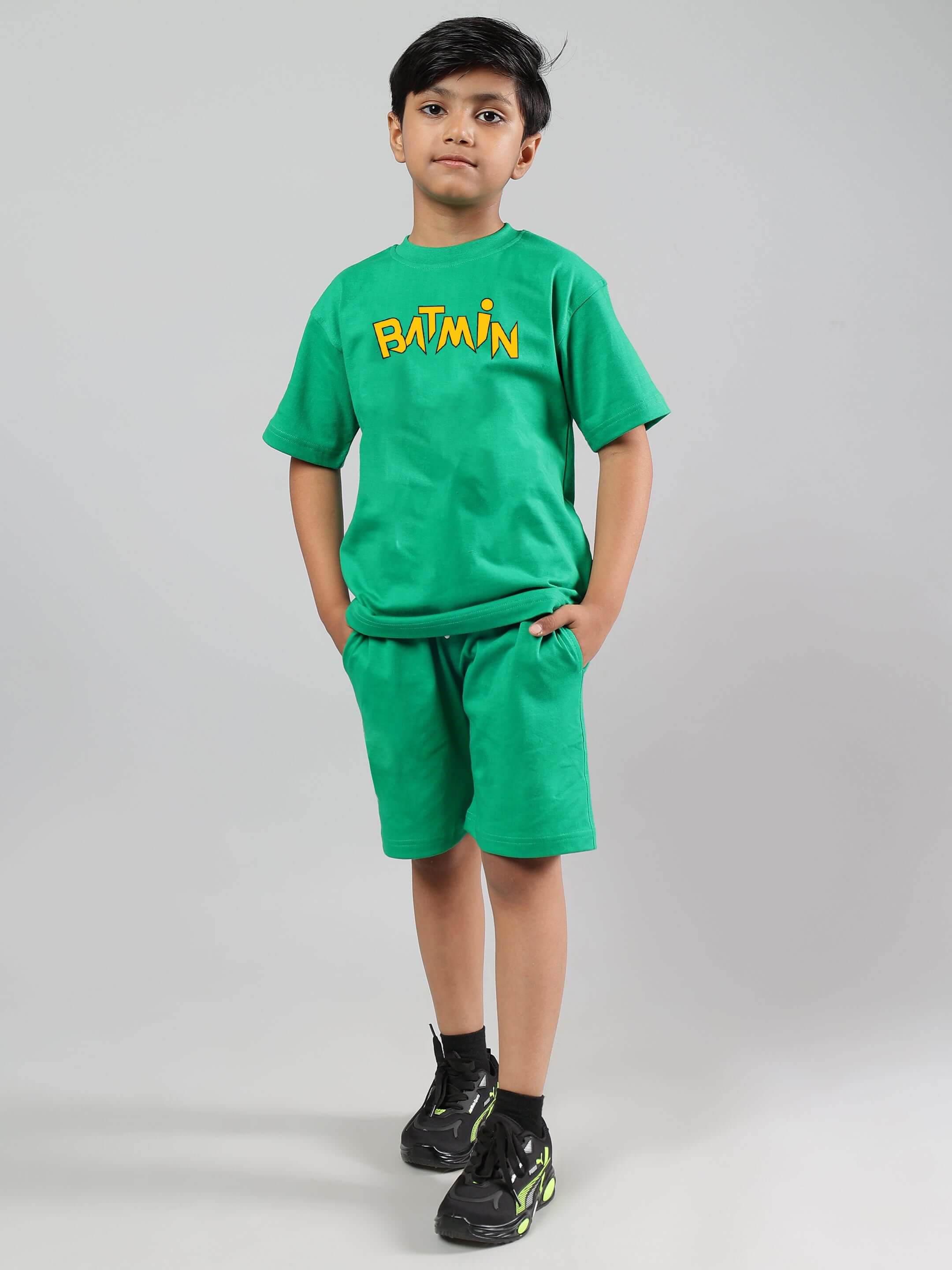Boy wearing green Batmin T-shirt and shorts, featuring a bold graphic design. Perfect for children's casual wear, 100% cotton.