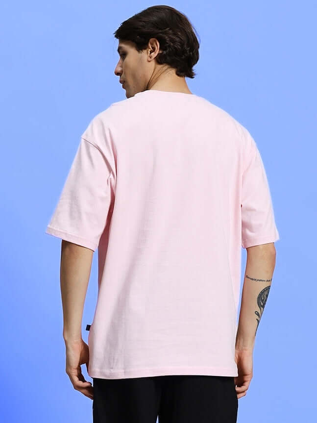 Man wearing BE KIND OVER-SIZED T-SHIRT PINK, back view.