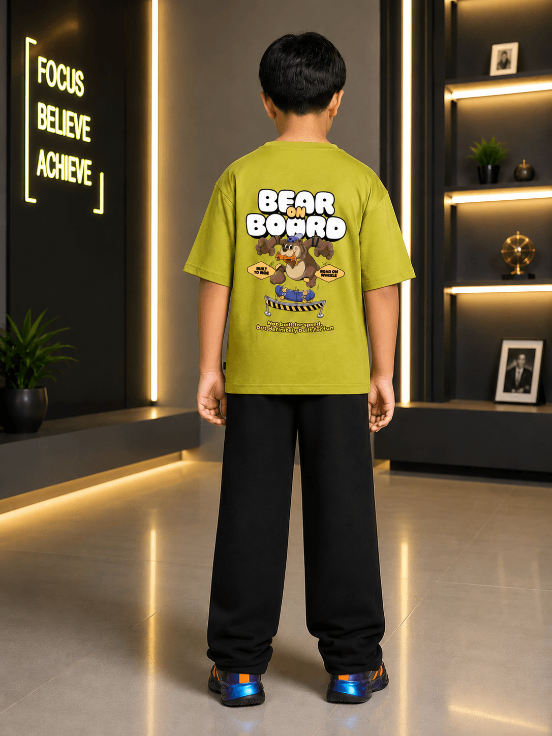 Boy wearing BEAR ON BOARD CO-ORD FOR BOYS GIRLS OLIVE GREEN BLACK, showcasing bear graphic on a stylish olive green shirt.