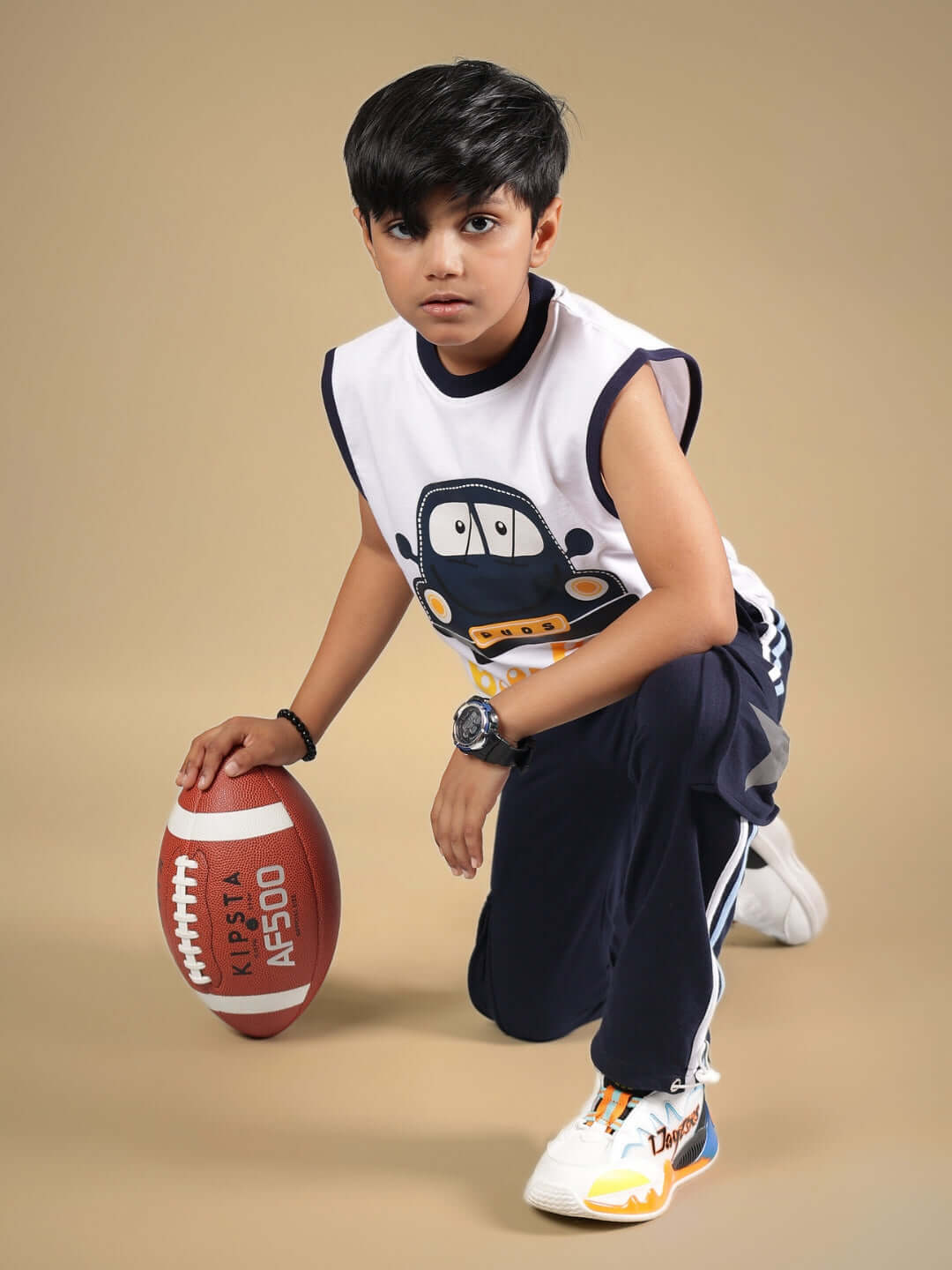 Child wearing BEEP BEEP CO-ORD FOR BOYS & GIRLS WHITE NAVY with football, showcasing trendy outfit for kids.