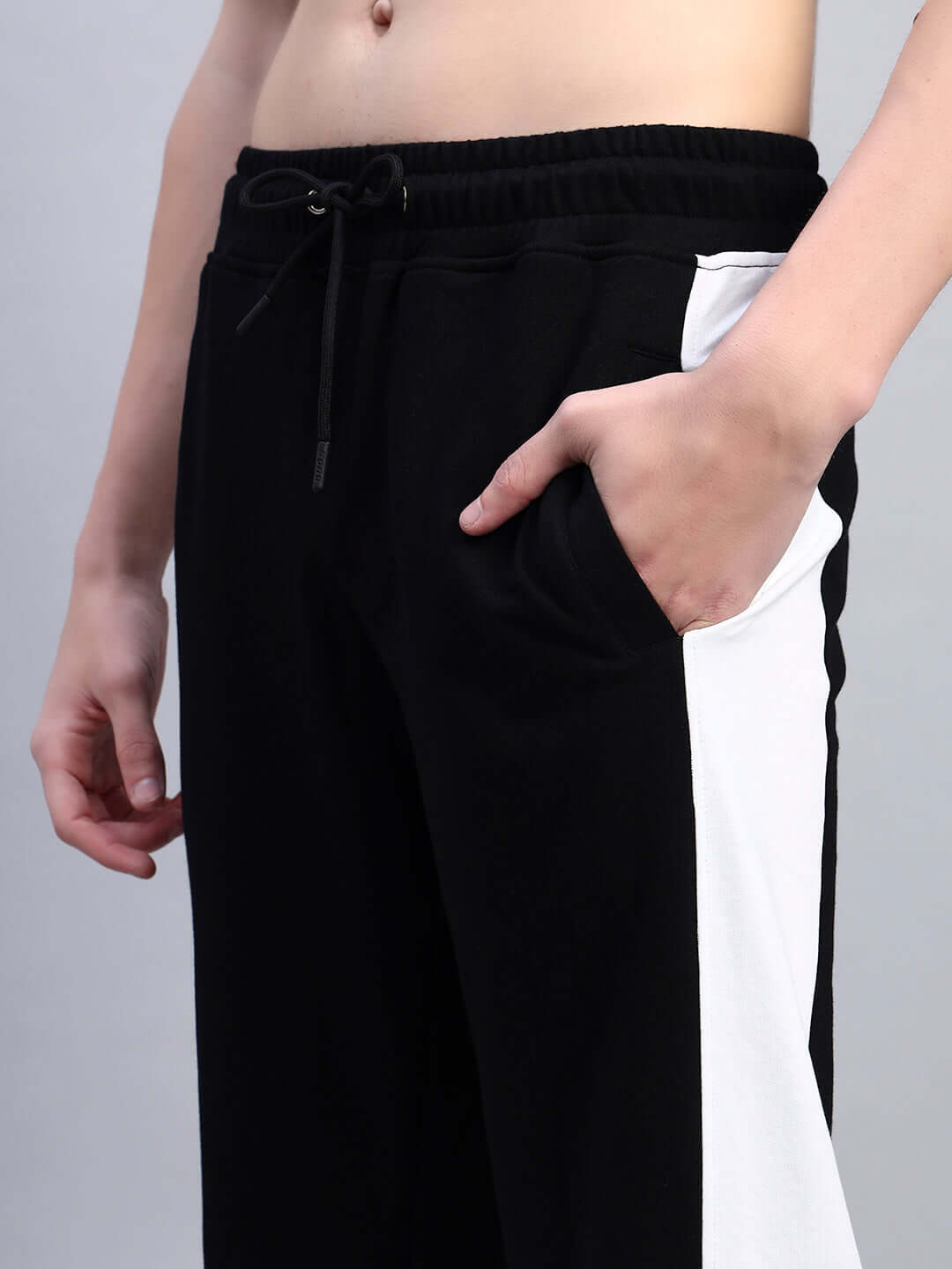 Close-up of BELGIANS RELAXED-FIT JOGGERS BLACK GREY with hand in pocket showcasing black-grey dual-tone design and comfort fit.