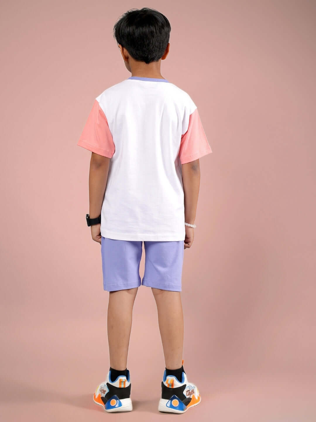 Back view of a child wearing BELIEVE CO-ORD FOR BOYS & GIRLS WHITE LAVENDER with white top and lavender shorts.