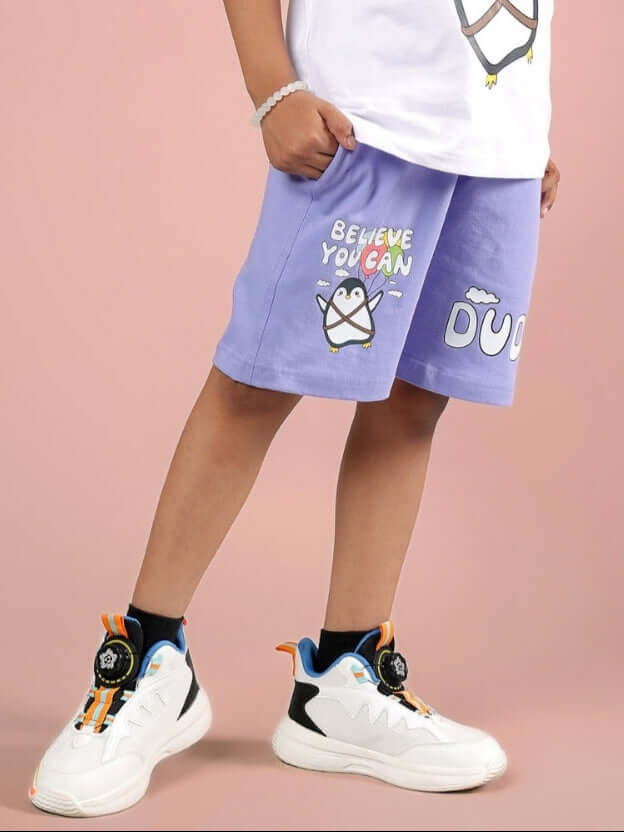 Child wearing BELIEVE SHORTS FOR BOYS & GIRLS LAVENDER with playful design on shorts.