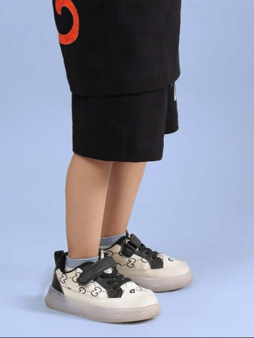Child wearing BINGO SHORTS FOR BOYS & GIRLS BLACK with stylish sneakers.