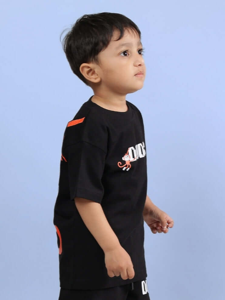 Young child wearing a BINGO T-SHIRT FOR BOYS GIRLS BLACK, featuring playful graphics for a fun look.