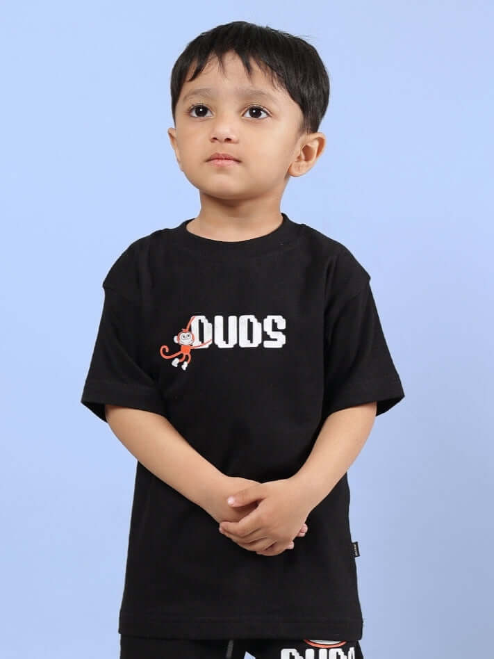 Child wearing BINGO T-SHIRT FOR BOYS GIRLS BLACK with playful monkey graphic on blue background.