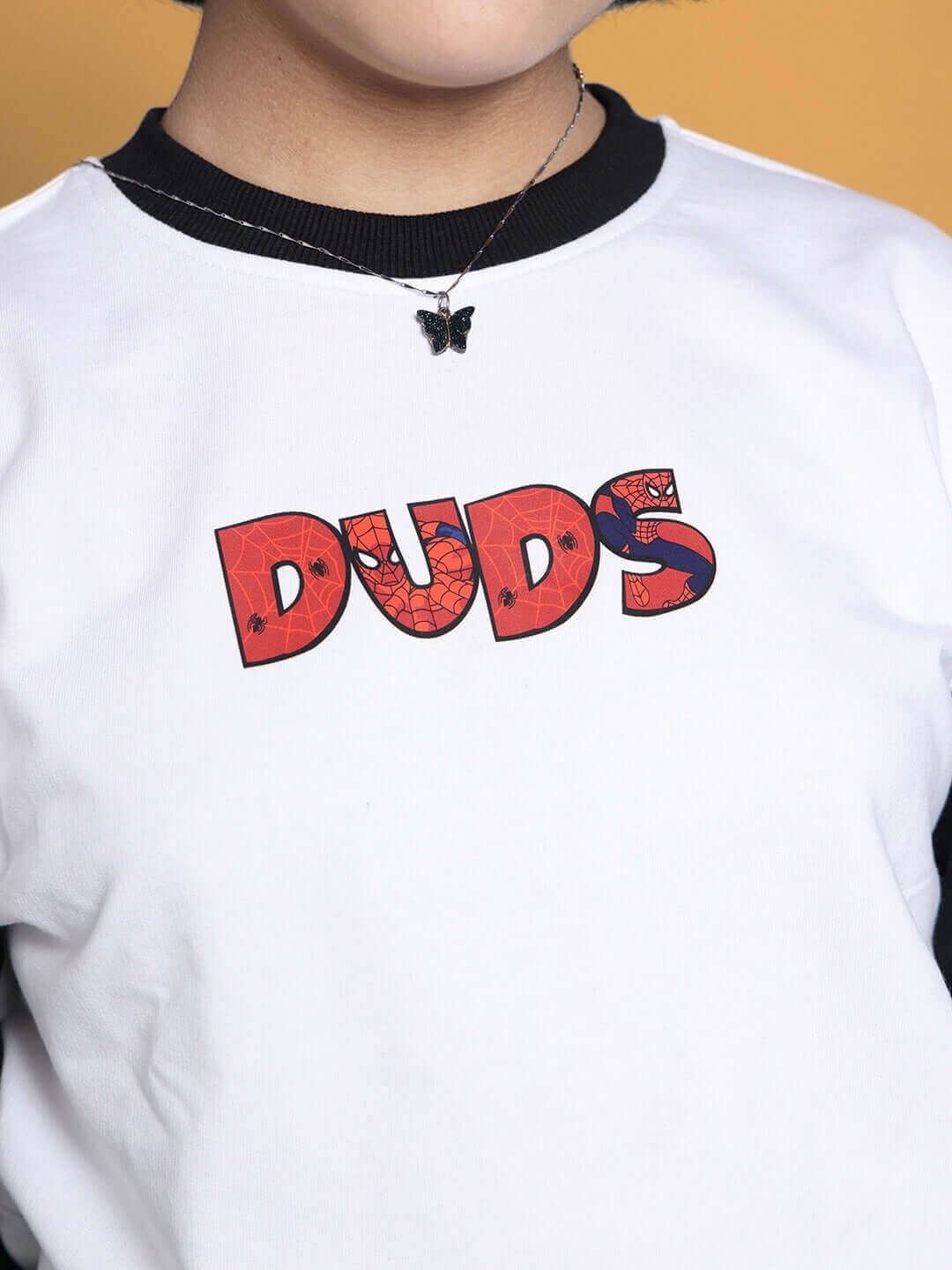 Child wearing white-black DUDS co-ord, featuring a colorful logo, perfect for boys and girls. Available for custom fit orders.