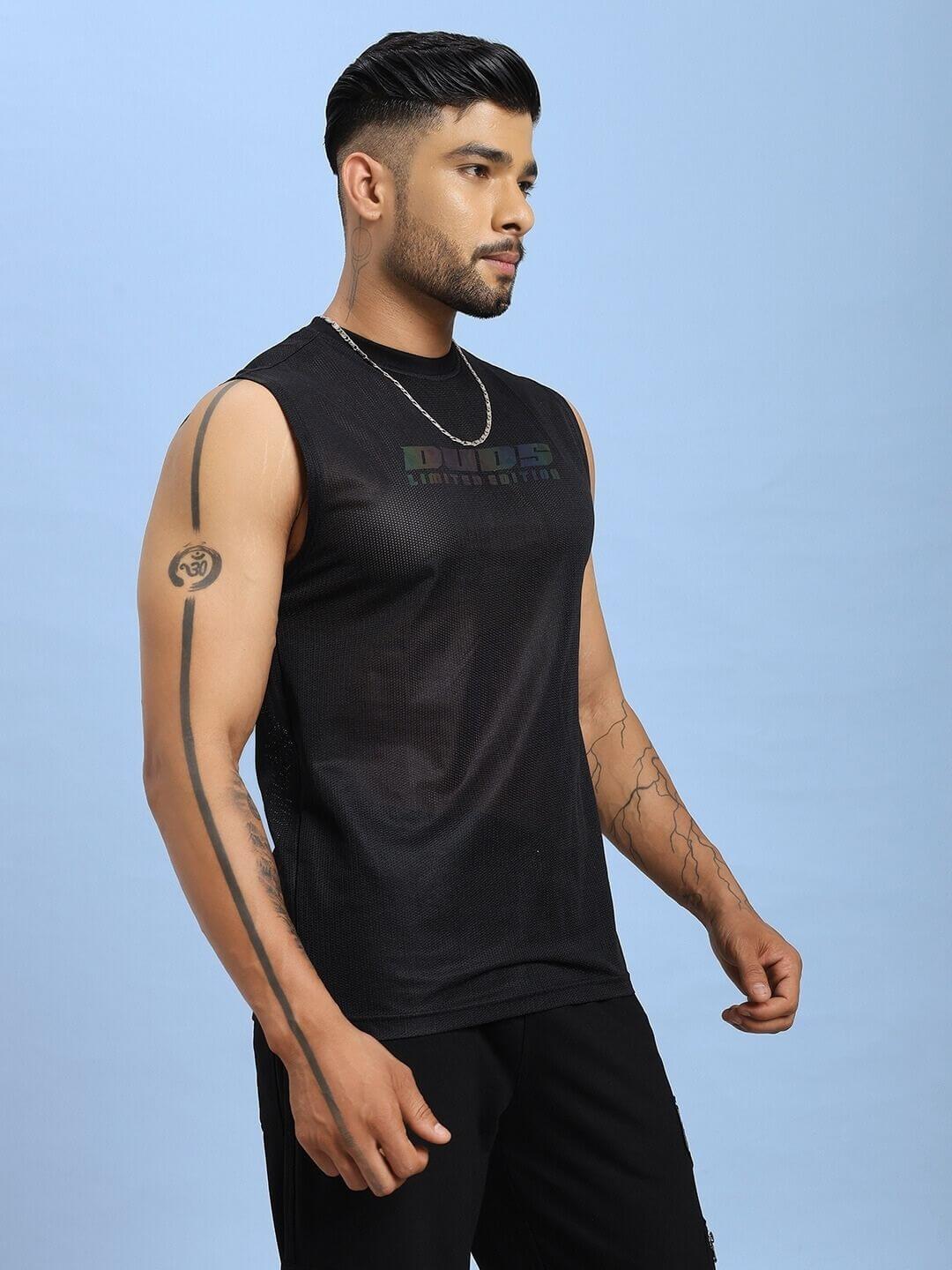 Man wearing AIR-FLOW REGULAR FIT T-SHIRT BLACK showcasing comfort and style against a blue background.