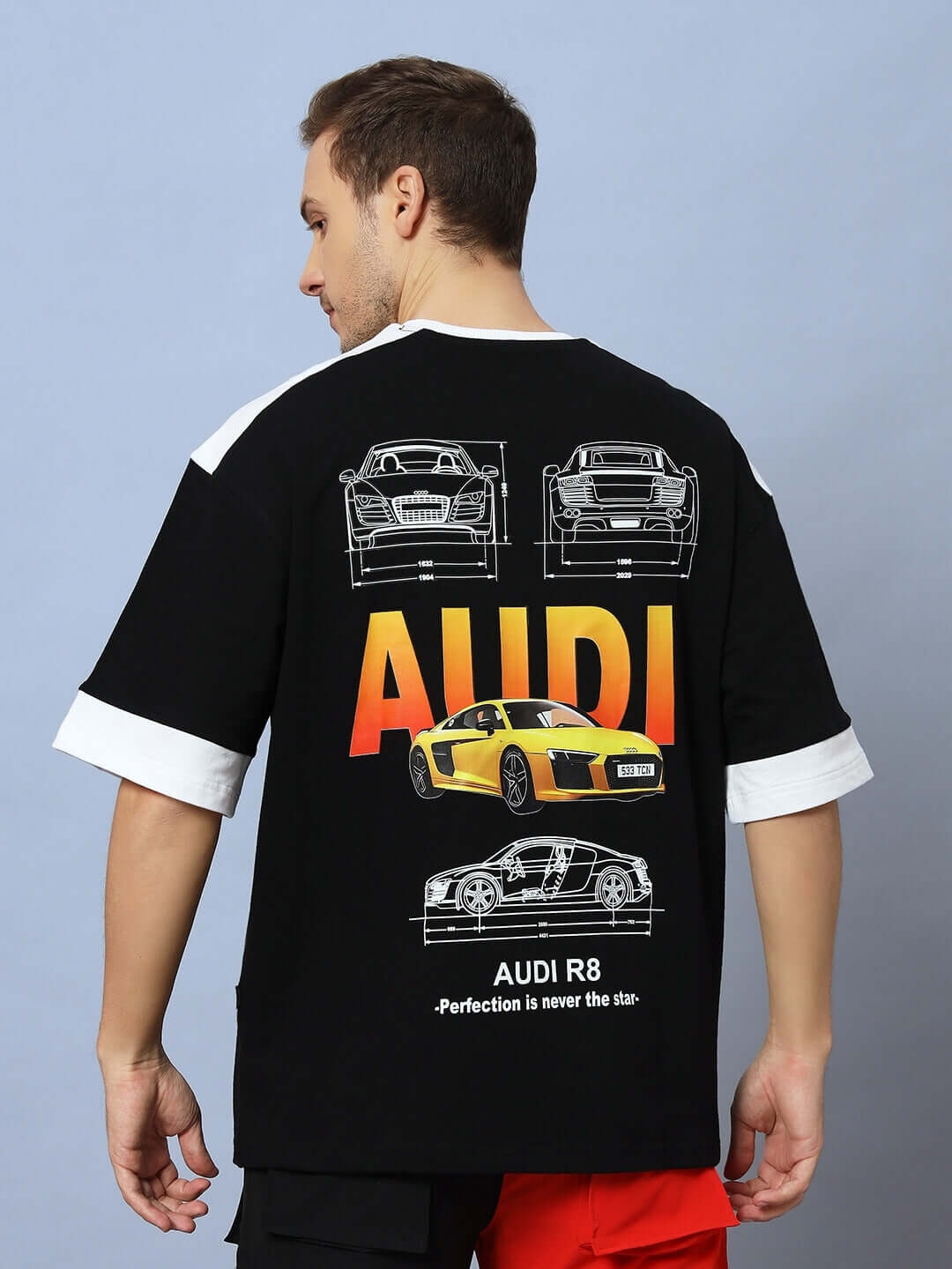 Model wearing AUDI R8 OVERSIZED T-SHIRT BLACK with a yellow Audi R8 graphic on the back, showcasing automotive-themed streetwear.