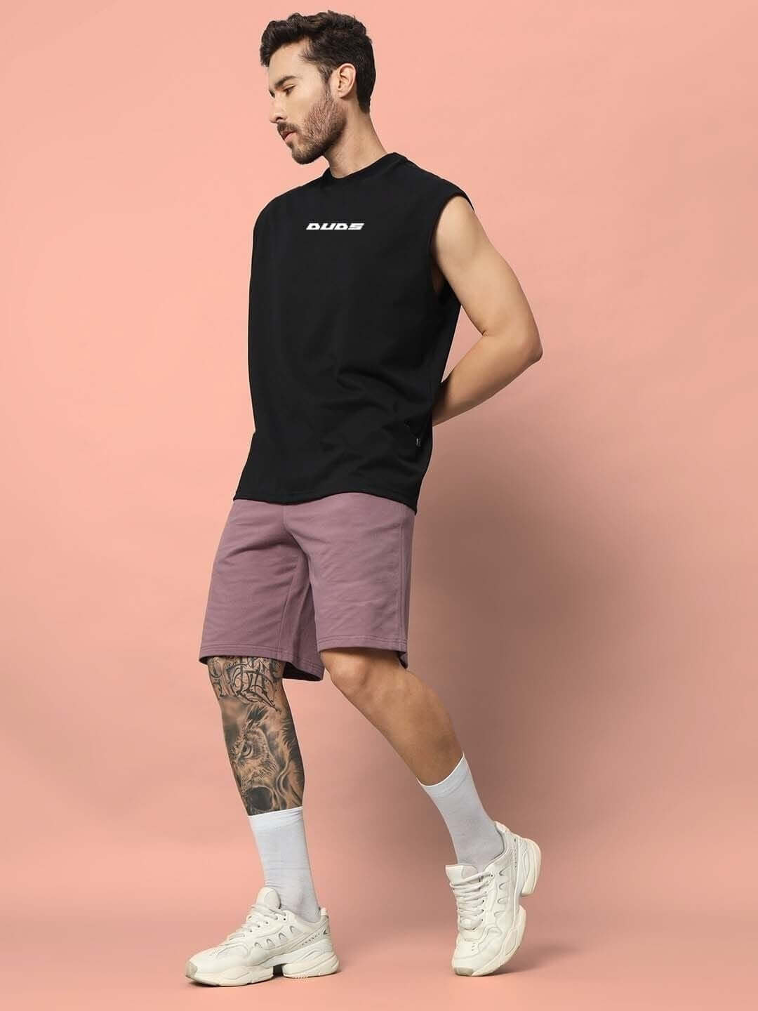 Male model wearing black Backbone Gym T-shirt and mauve shorts, demonstrating casual sports fashion.