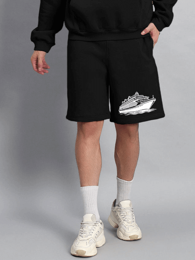 RULE THE WORLD FLEECE CO-ORD - BLACK showcasing stylish black fleece shorts with a cruise ship print, paired with white sneakers.