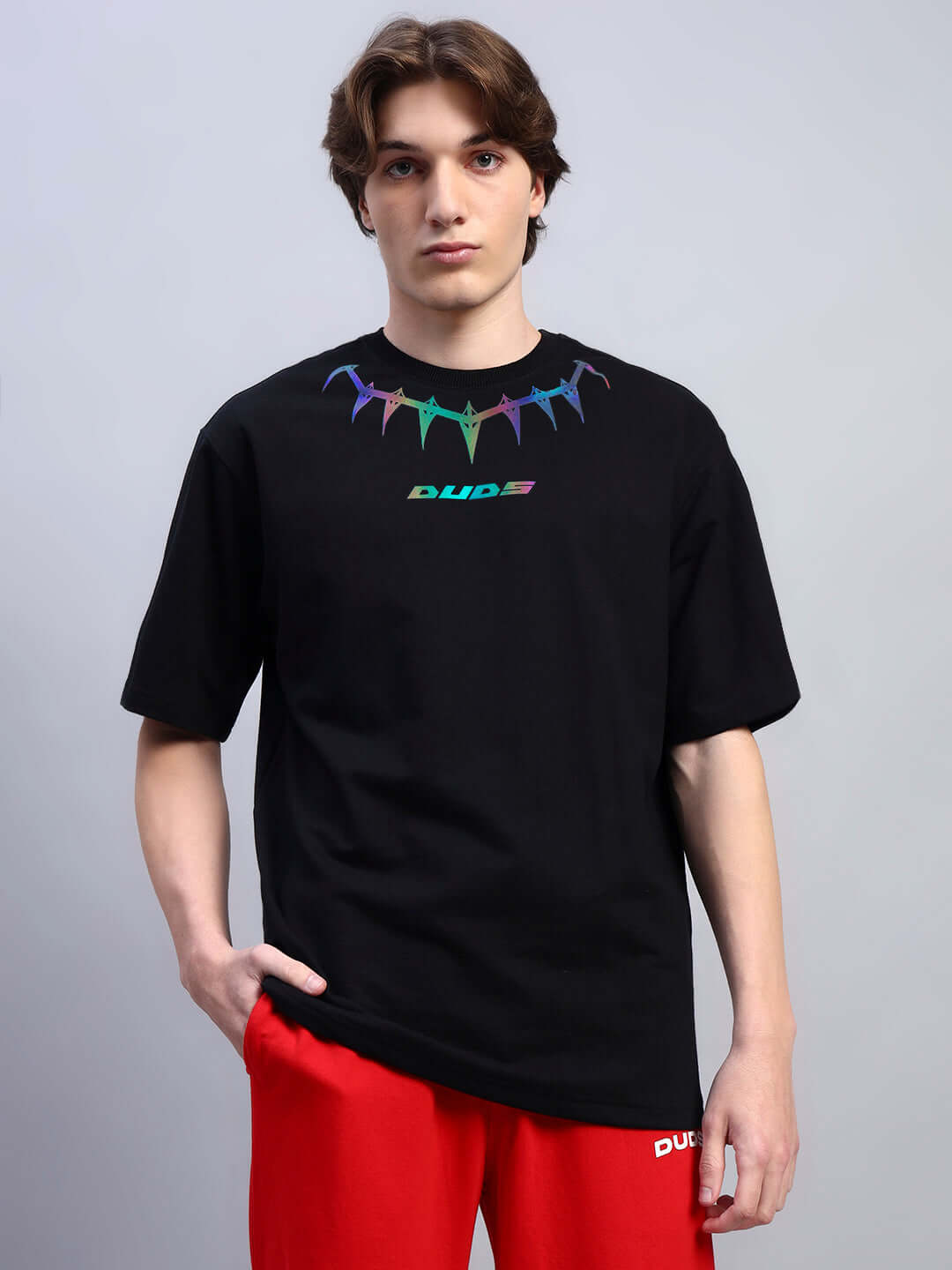 Model wearing Black Panther oversized T-shirt, featuring premium cotton fabric and colorful design, paired with red trousers.