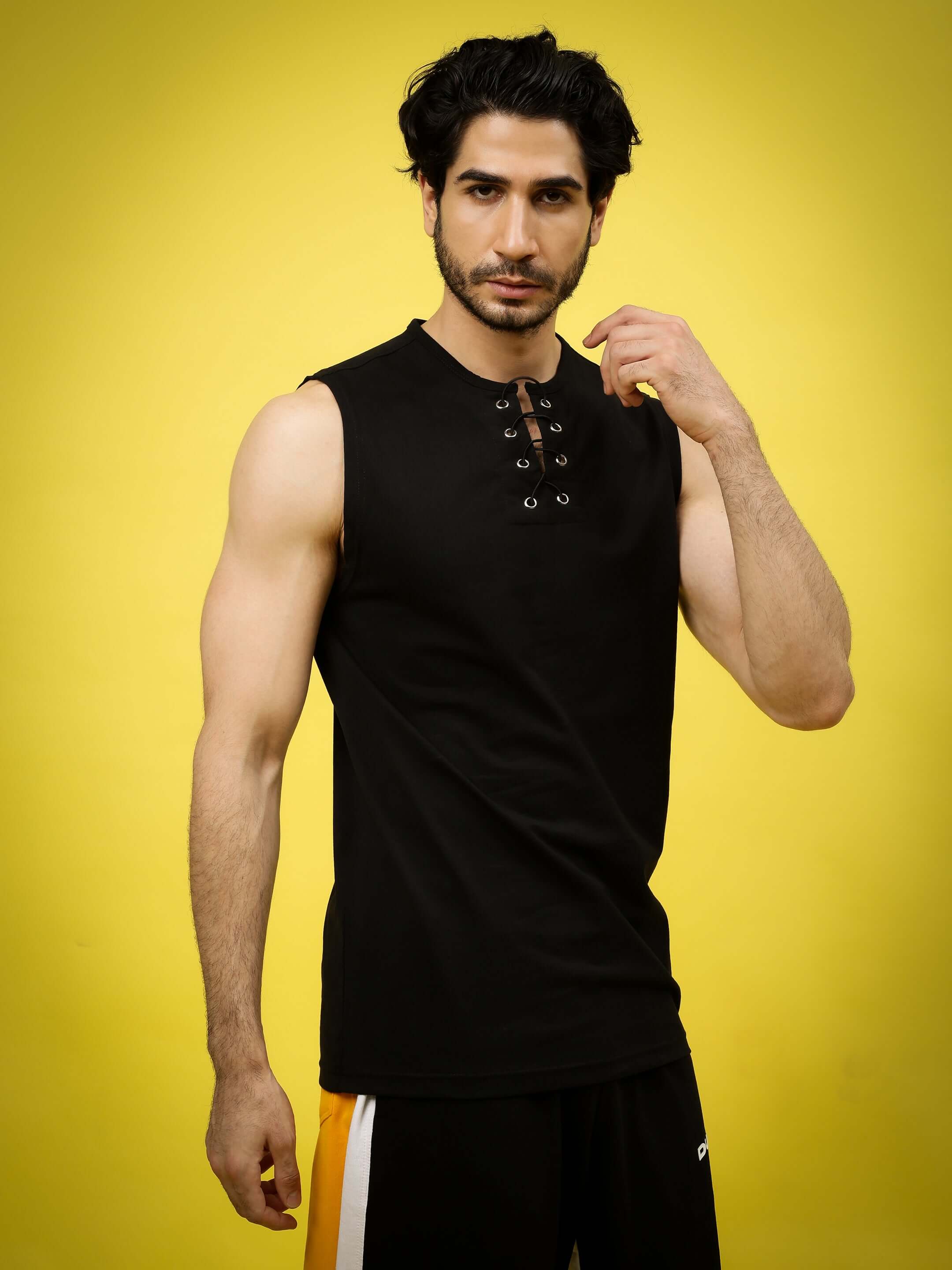 Man wearing PINNACLE Regular Fit Black T-Shirt against yellow background.