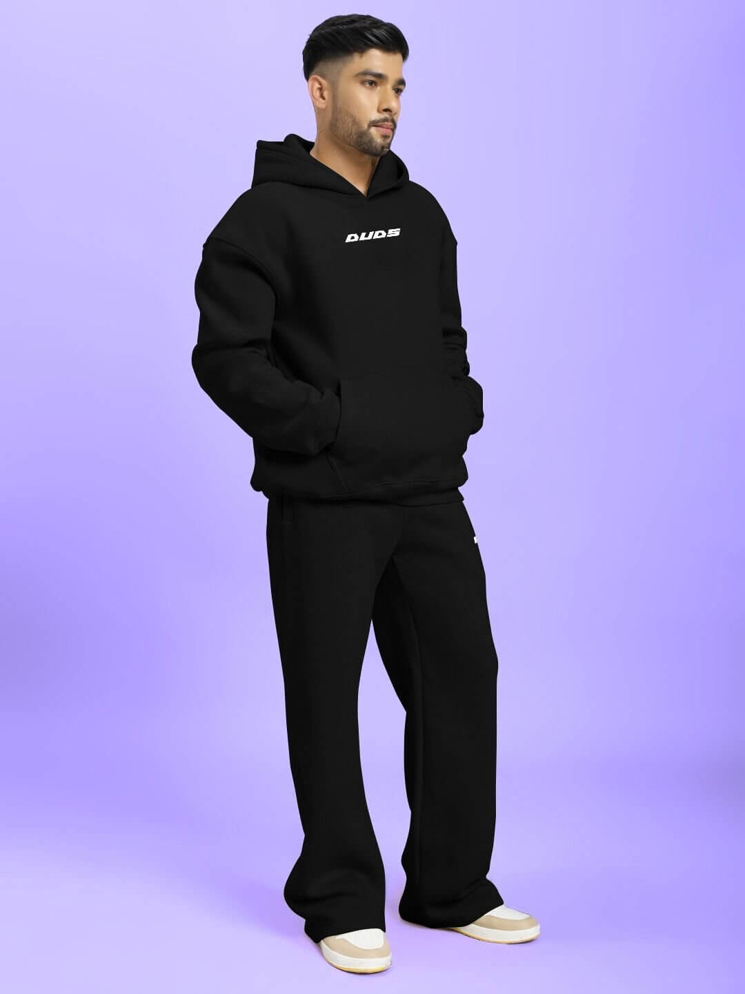 Model wearing SILVER SURFER FLEECE CO-ORD SET BLACK, standing against purple background.