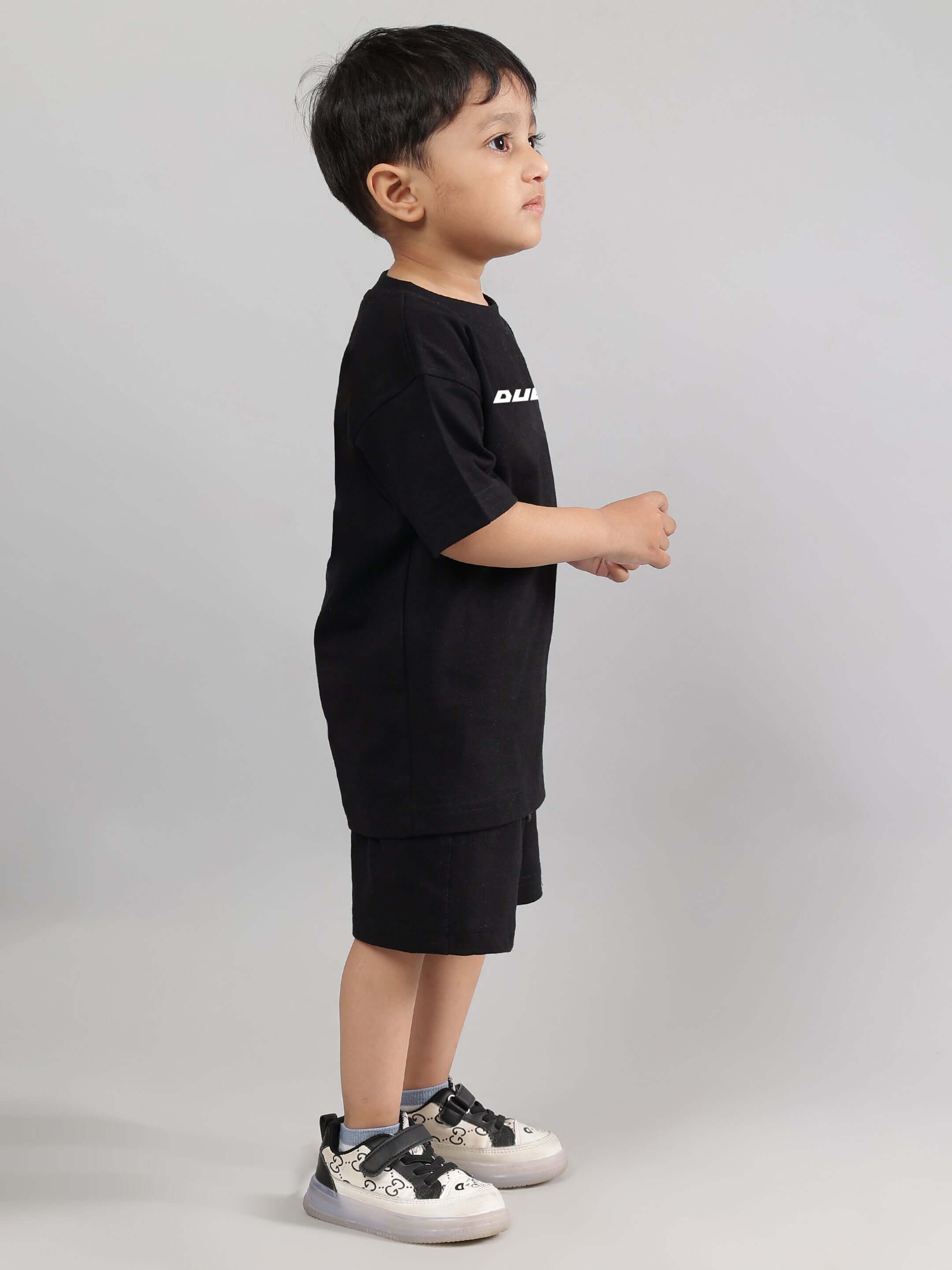 Child wearing ENJOY THE WIND CO-ORD FOR BOYS GIRLS BLACK with sneakers, showcasing trendy unisex fashion for kids.