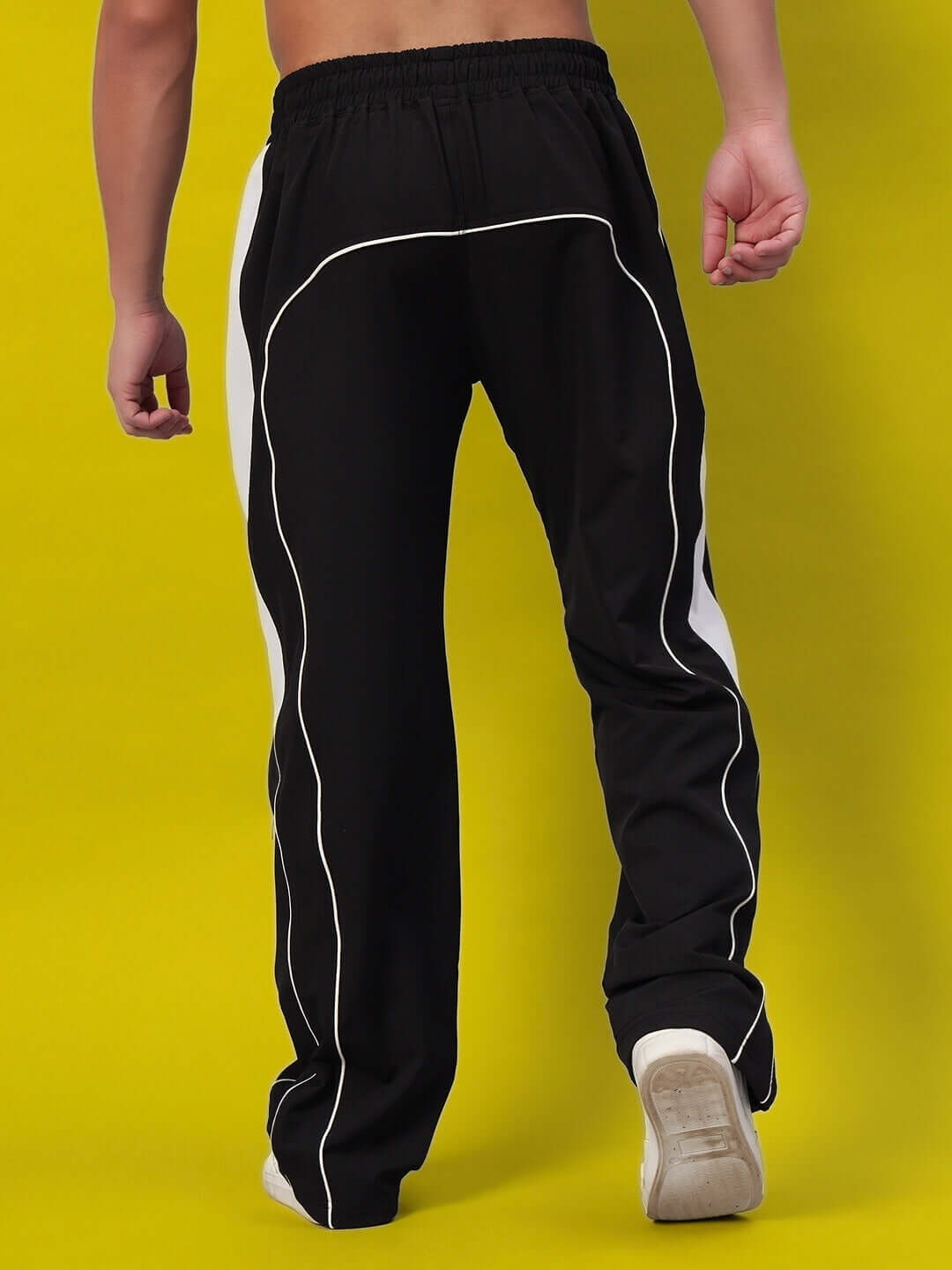Back view of black versatile parachute cargo pants with white accents, showcasing comfort and style, suitable for custom fit orders.