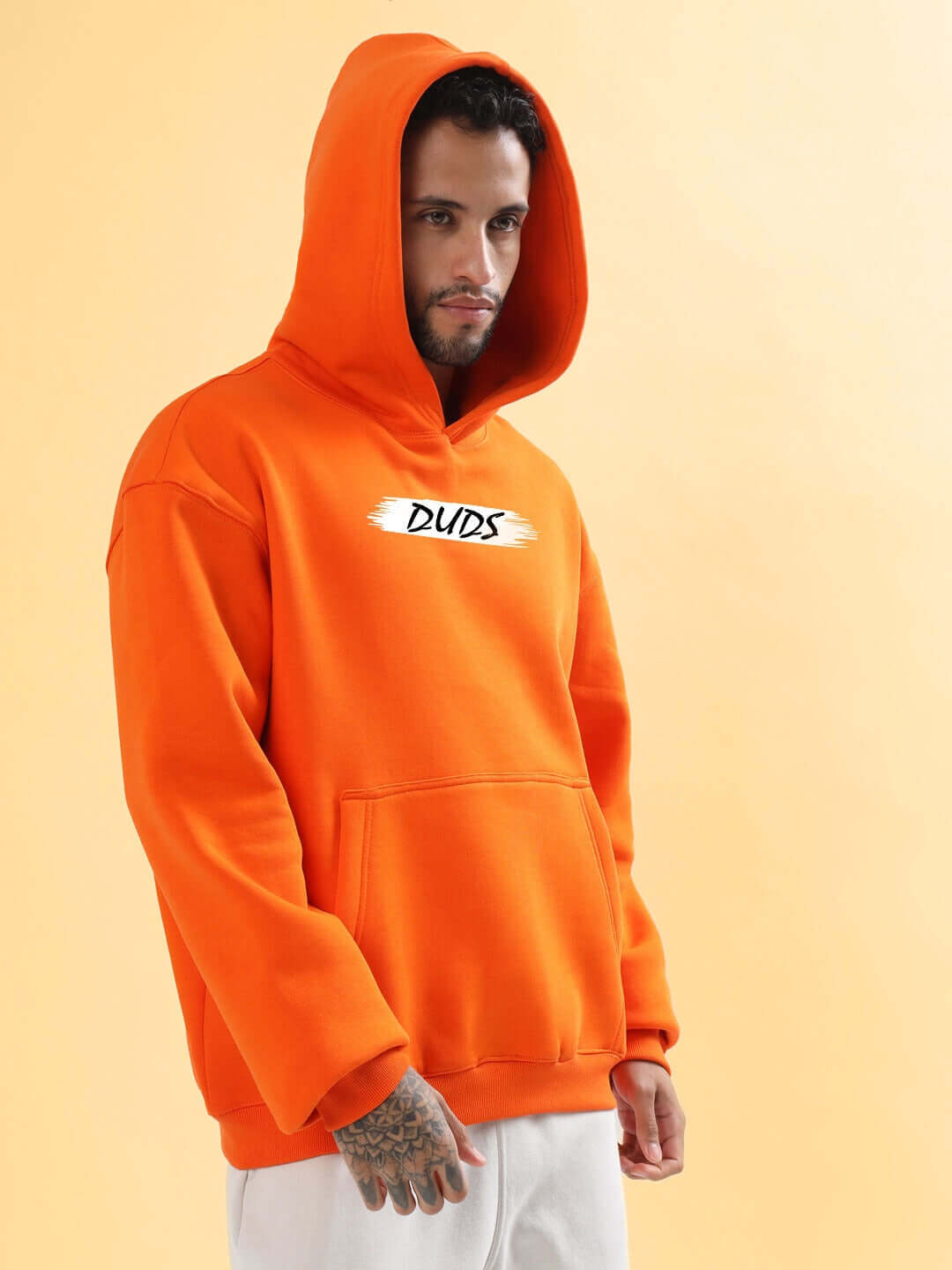 Model wearing BLOOM QUOTE FLEECE OVERSIZED HOODIE ORANGE, showcasing its vibrant color and relaxed fit, perfect for casual wear.