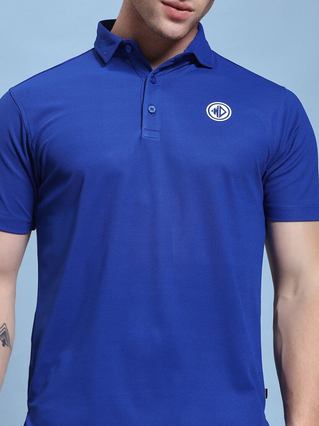 Man wearing ROSEWOOD CO-ORD SET BLUE BLACK, blue and black modern streetwear, featuring a stylish polo shirt with logo.