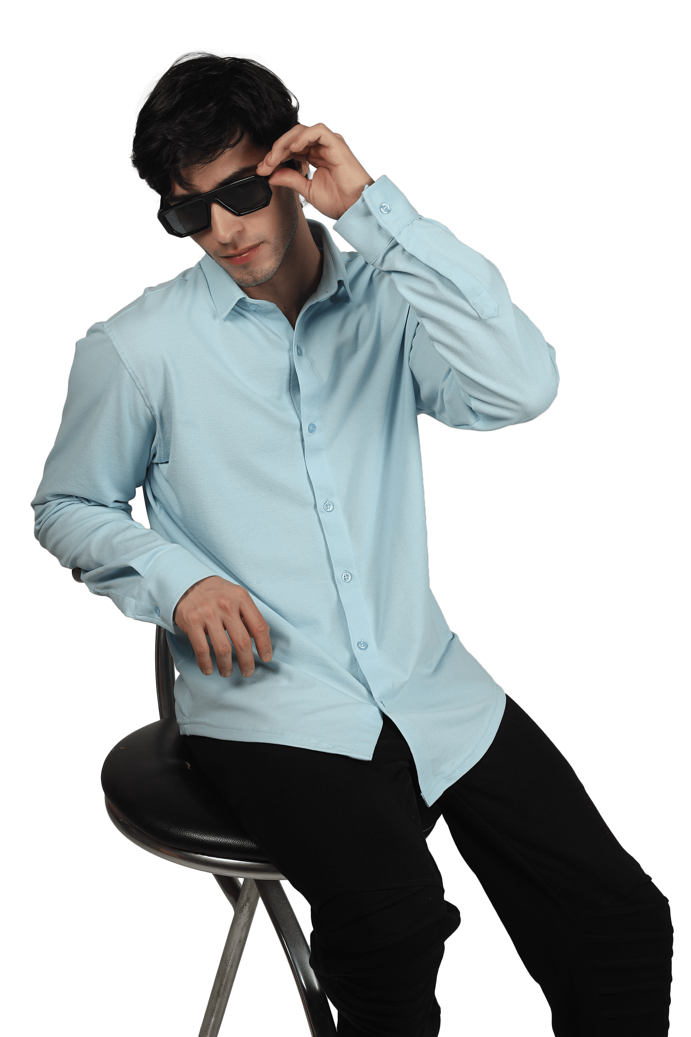 Model wearing a powder blue sporty pique shirt with full sleeves, sitting and adjusting sunglasses. Features include wrinkle-free and stretch fabric.