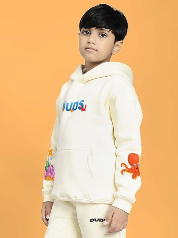 Child wearing BLUE OCEAN WORLD FLEECE HOODIE FOR BOYS AND GIRLS OFF-WHITE with colorful sea creature designs
