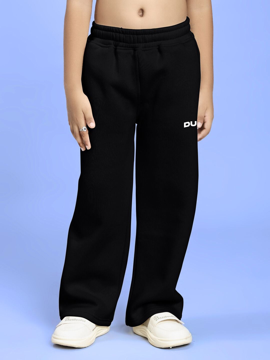 Child wearing BLUE OCEAN WORLD FLEECE JOGGER FOR BOYS AND GIRLS BLACK in cozy fleece fabric on a blue background.