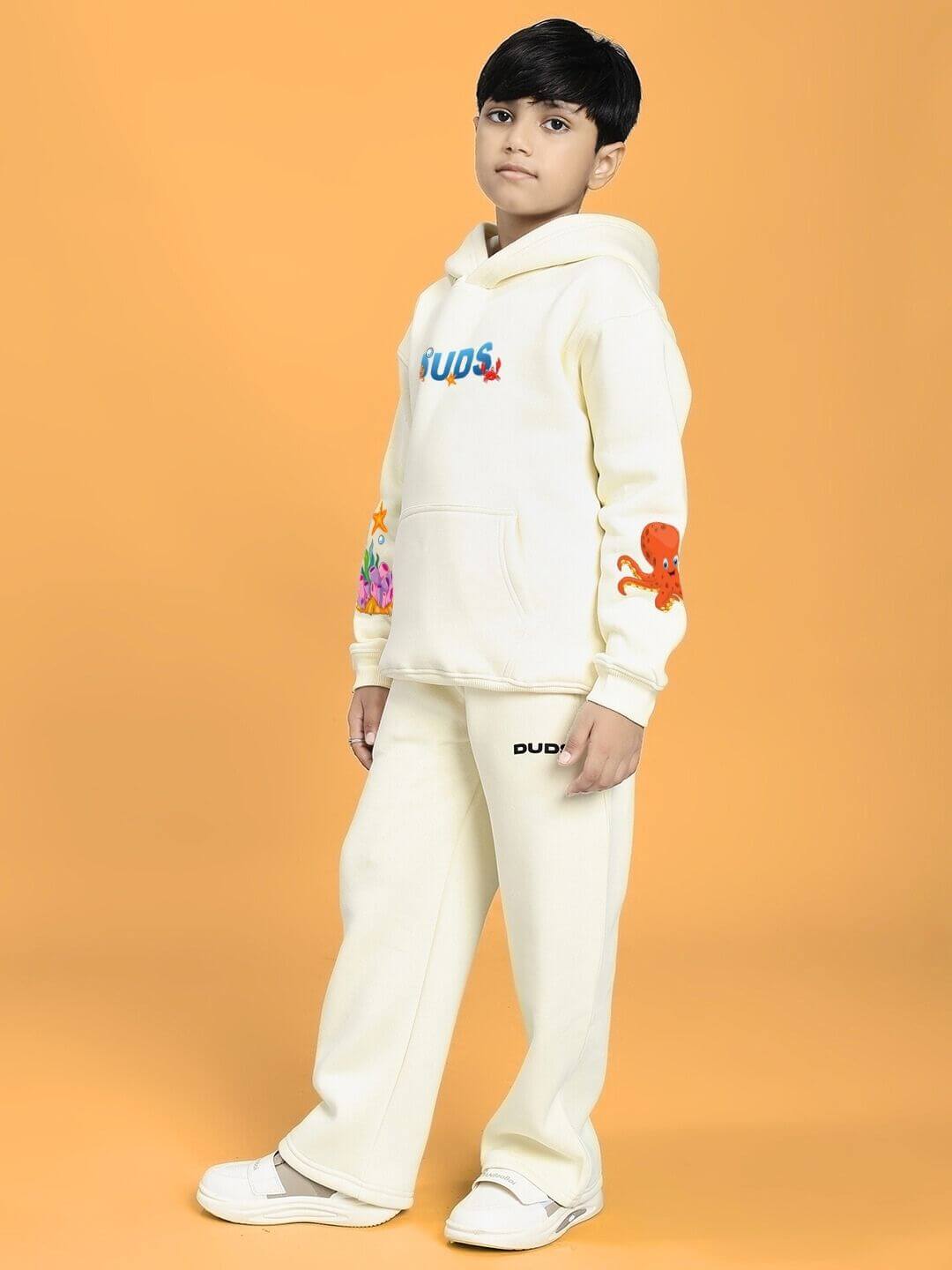 Child wearing BLUE OCEAN WORLD FLEECE JOGGER FOR BOYS AND GIRLS OFF-WHITE in a casual pose, showcasing off-white design and graphics.
