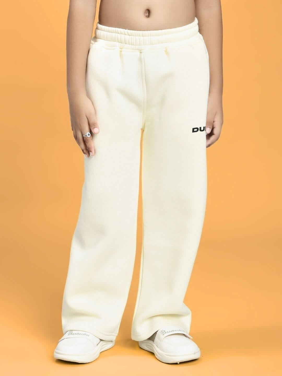Child wearing BLUE OCEAN WORLD FLEECE JOGGER FOR BOYS AND GIRLS OFF-WHITE with elastic waistband and casual fit.