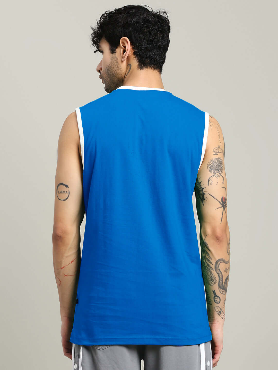 Man wearing NO BAD VIBES SLEEVLESS GYM T-SHIRT BLUE, rear view showing design.
