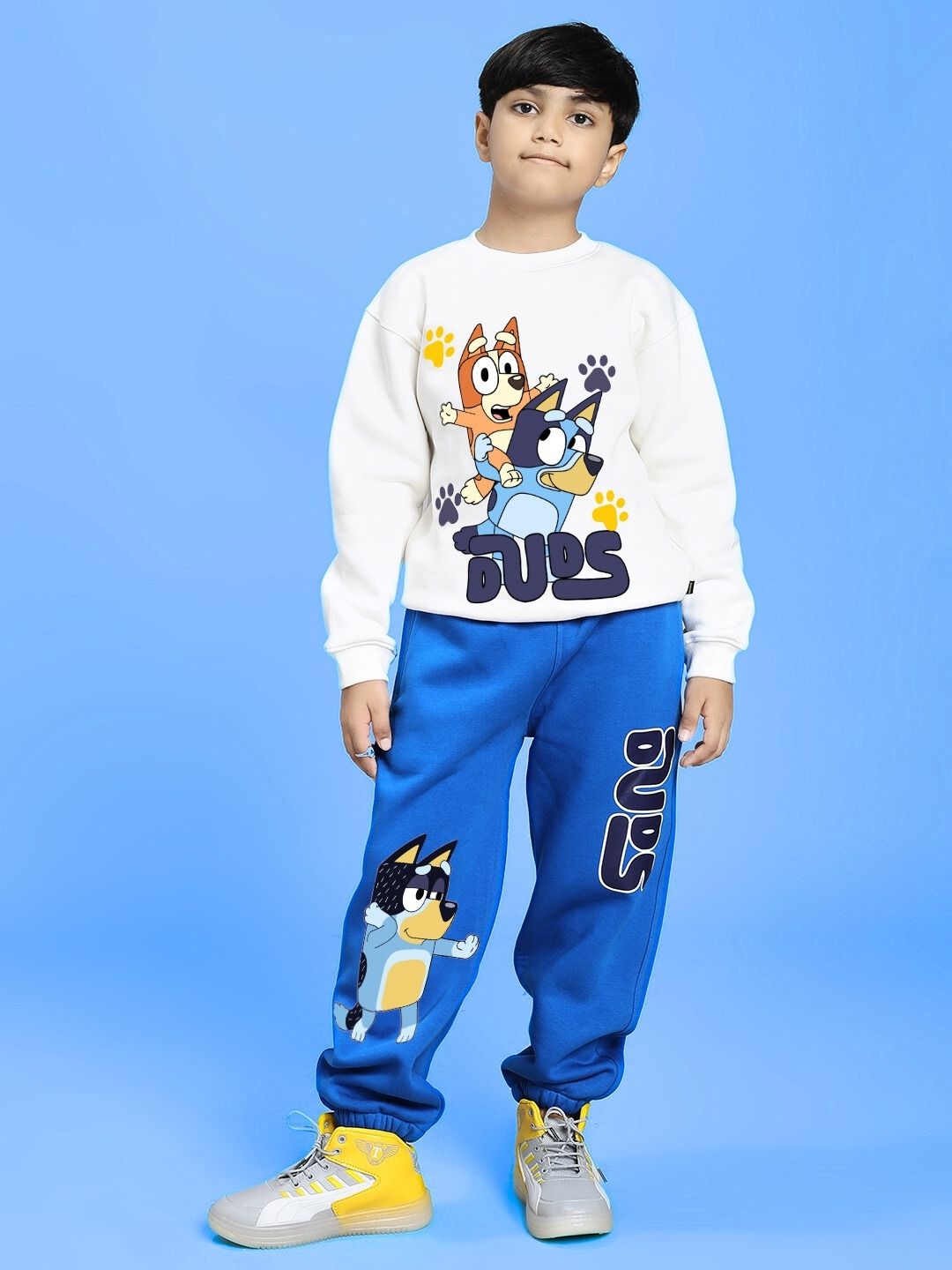 Child wearing a BLUEY BINGO FLEECE CO-ORD FOR BOYS AND GIRLS WHITE BLUE with cartoon characters on blue background