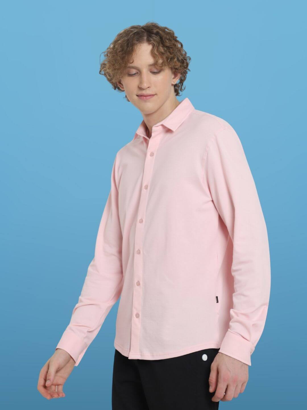 Model wearing blush pink sporty pique shirt with full sleeves and curved hem, showcasing slim fit and comfortable, wrinkle-free fabric.