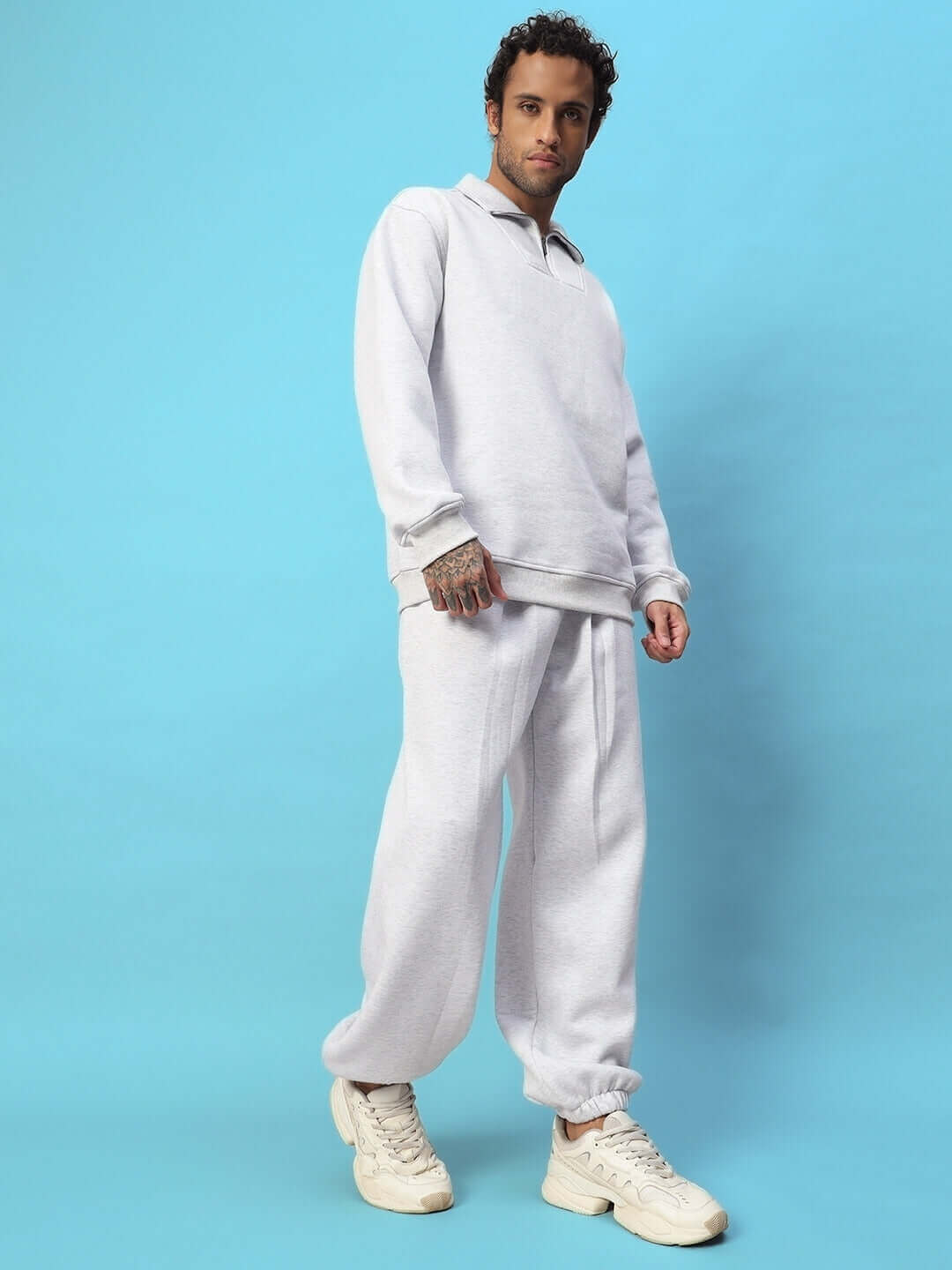 Model wearing Bona-Fide Sweatshirt in melange grey, showcasing a relaxed fit for casual streetwear style against a blue background.