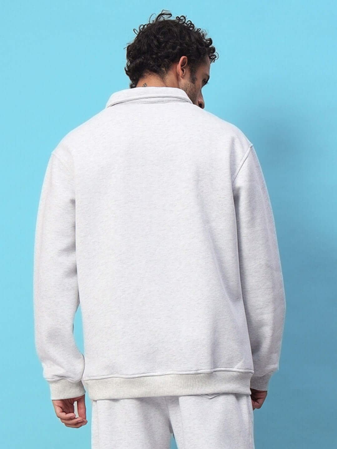 Back view of a man wearing a Bona-Fide Melange Grey Sweatshirt, showcasing its relaxed fit and soft cotton-blend fleece texture.