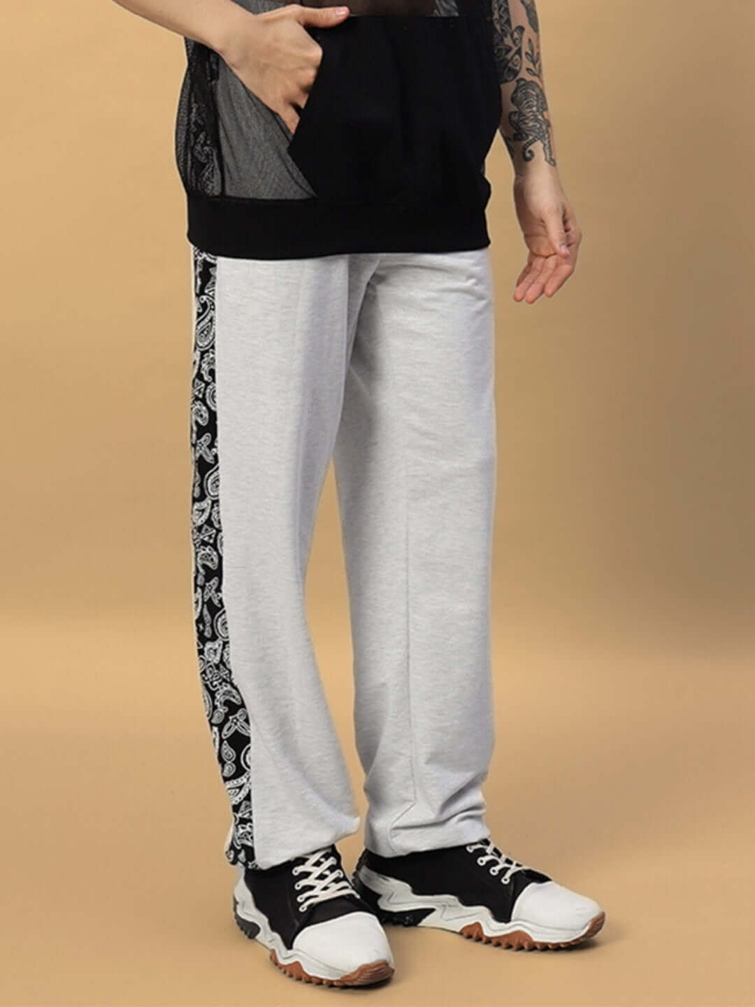Person wearing Boogie Relaxed Fit Joggers in melange grey with black and white side patterns, showcasing casual streetwear style.