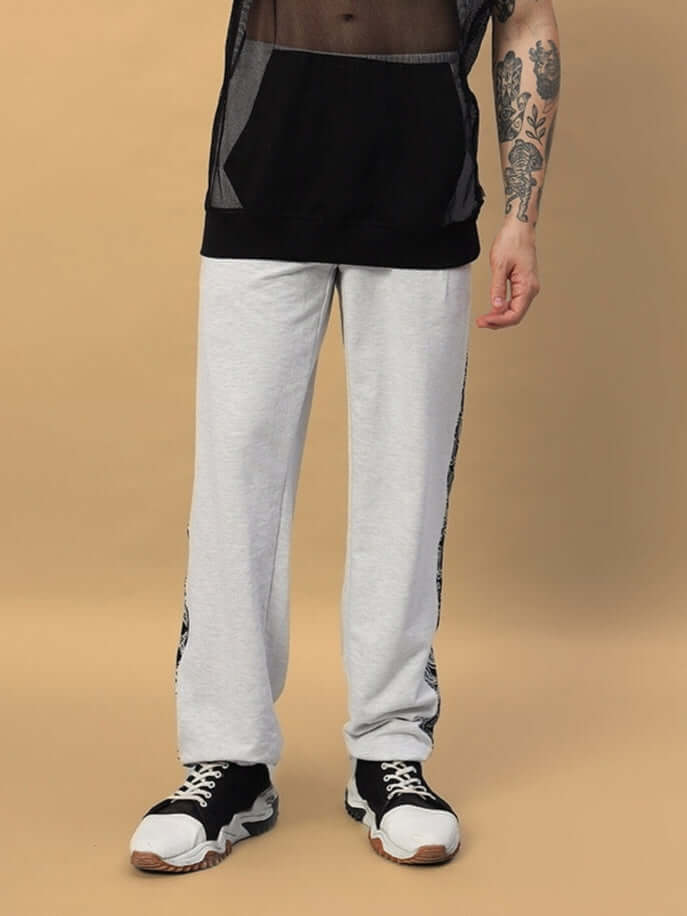 Man wearing Boogie Relaxed Fit Joggers in melange grey, paired with black sneakers, showcasing comfortable and stylish attire by DUDS.