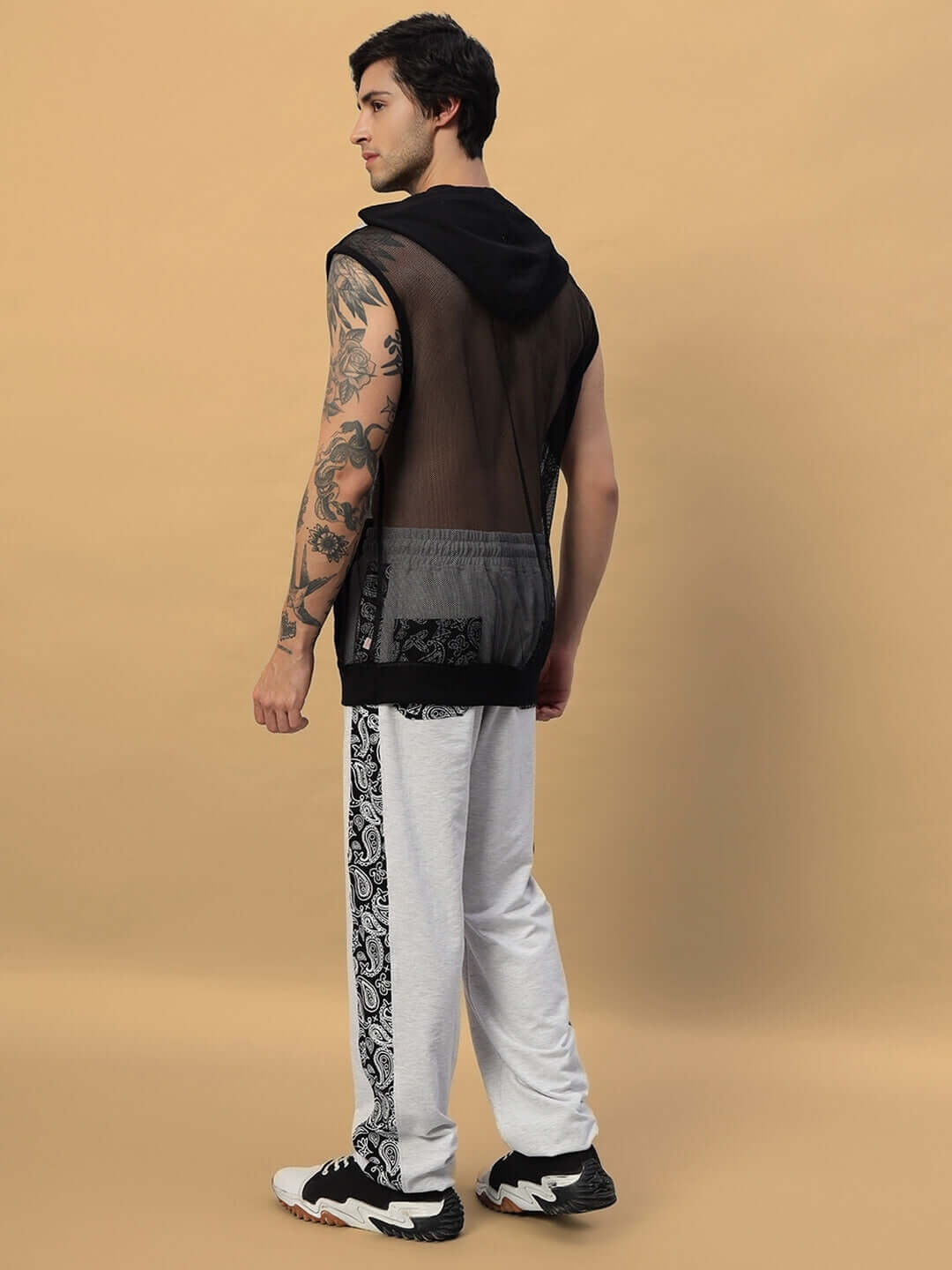 Model wearing Boogie Relaxed Fit Joggers in melange grey with side patterns, paired with black mesh hoodie, showcasing casual street style.