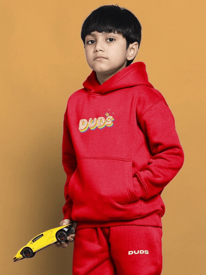 Boy wearing red "Born to Shine" oversized hoodie with toy car, ideal for boys and girls.