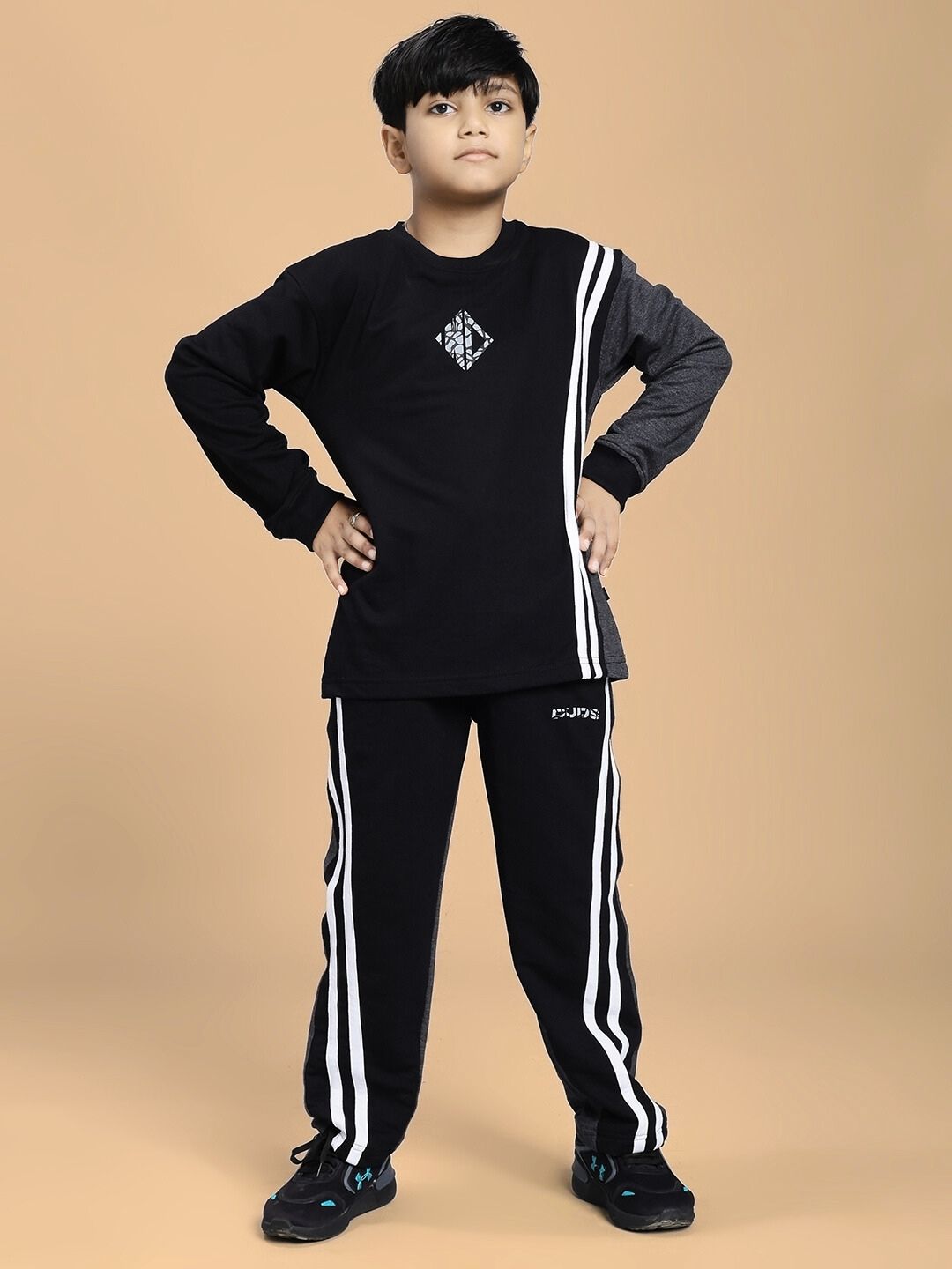 Boy wearing BOSCO STRIPE CO-ORD SET FOR BOYS AND GIRLS BLACK DARK GREY, showcasing a matching black and grey sweatshirt and joggers.