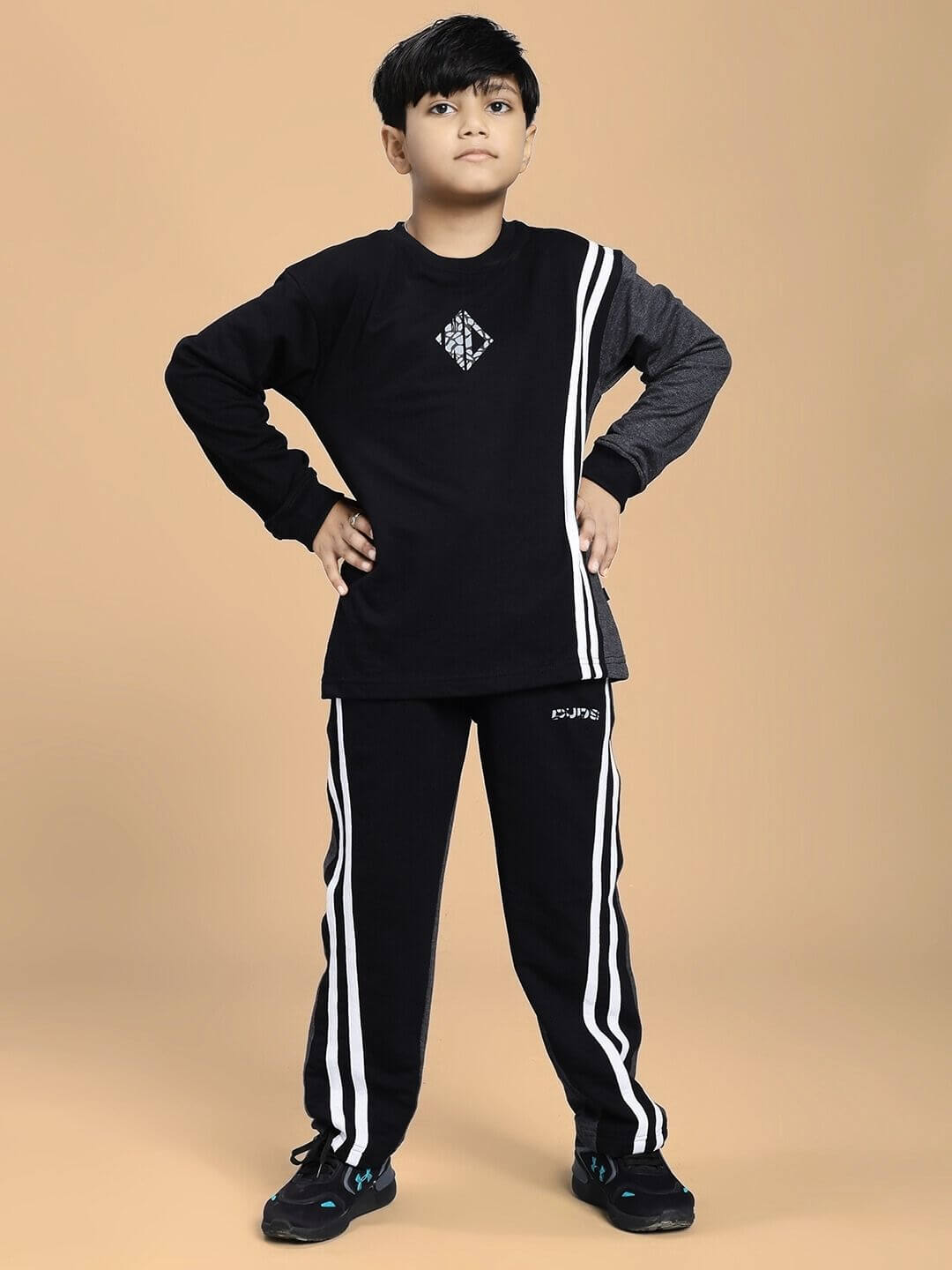 Boy wearing BOSCO STRIPE JOGGER FOR BOYS AND GIRLS BLACK DARK GREY with hands on hips stylishly posing in trendy outfit.