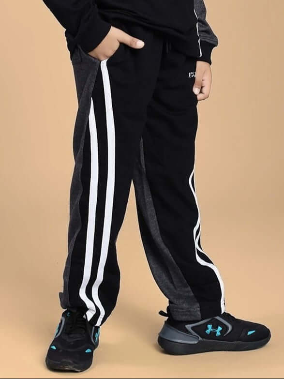 Child wearing BOSCO STRIPE JOGGER FOR BOYS AND GIRLS BLACK DARK GREY, showcasing comfort and style with white stripes down the sides.