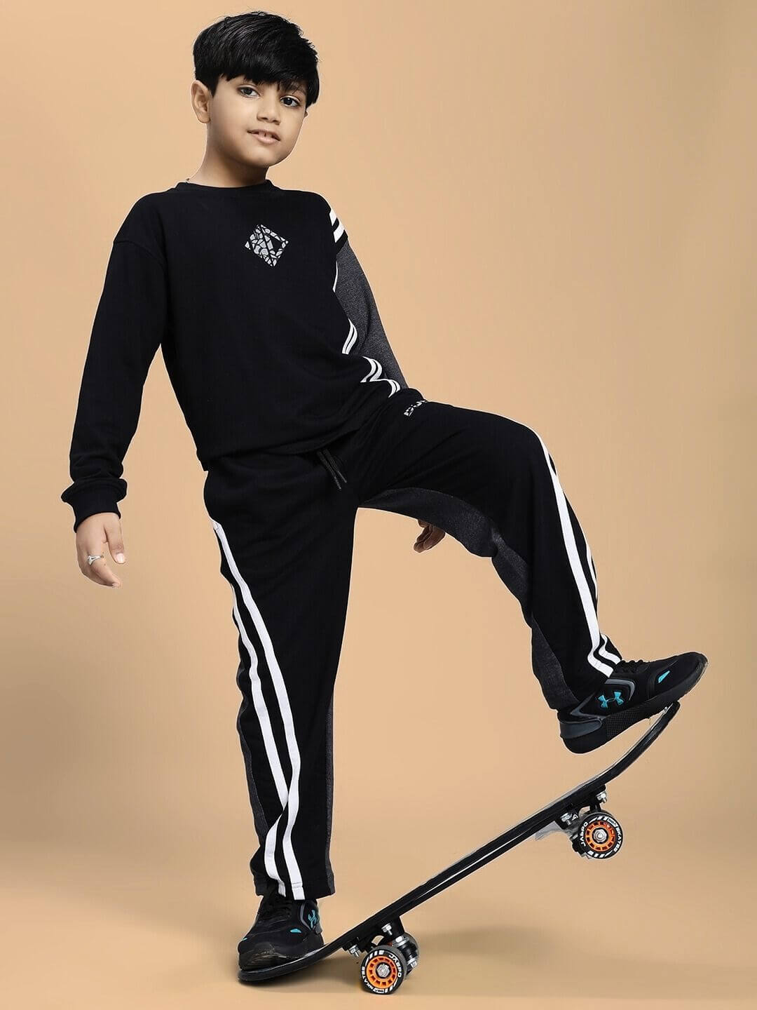 Child wearing BOSCO STRIPE SWEATSHIRT BOYS AND GIRLS BLACK DARK GREY with skateboard, showcasing style and versatility.