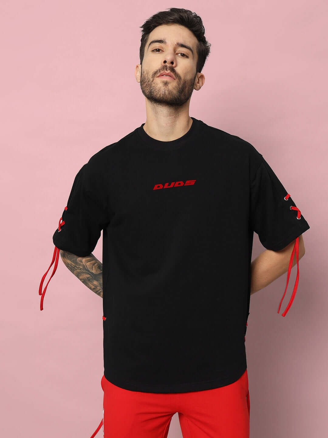BOWLINE OVER-SIZED T-SHIRT BLACK on a person with minimalist design and red accents, perfect for casual wear or layering.