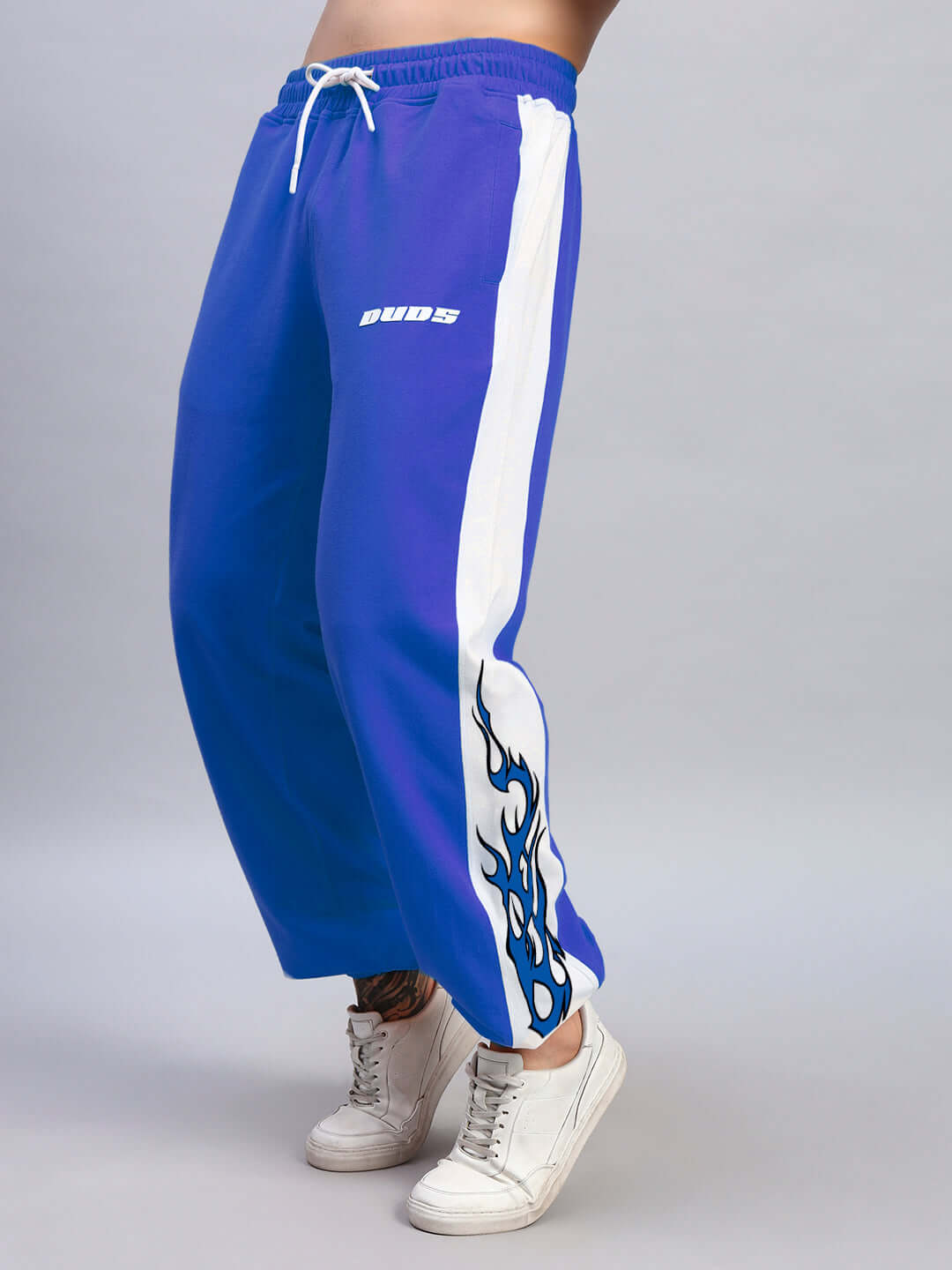 Person wearing BRACER RELAXED FIT JOGGERS BLUE-WHITE with flame design, showcasing sporty style and casual comfort.