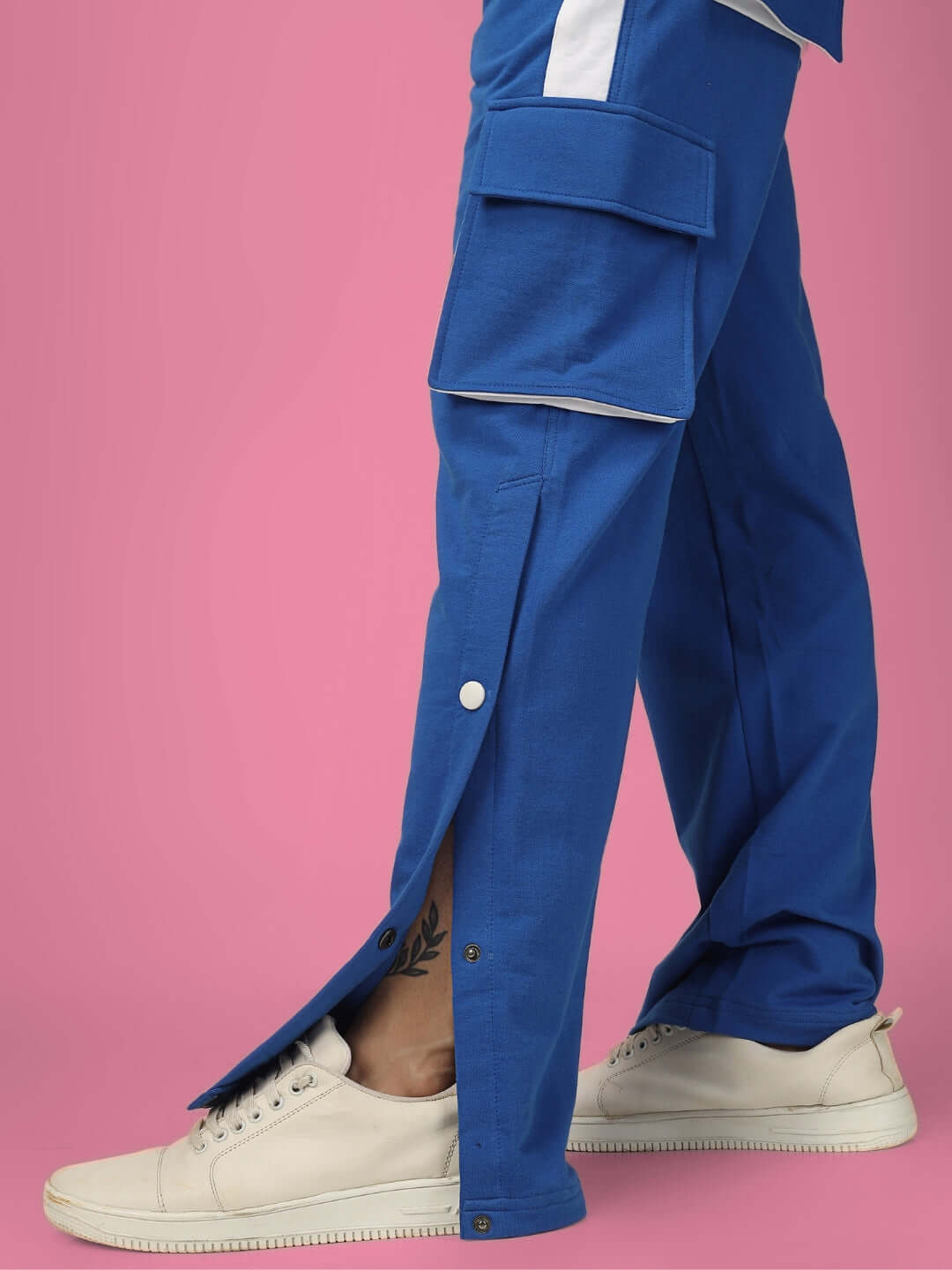 Person wearing BRACKET Cargo Pants in blue with white stripes, featuring adjustable side buttons and cargo pockets, made by DUDS.