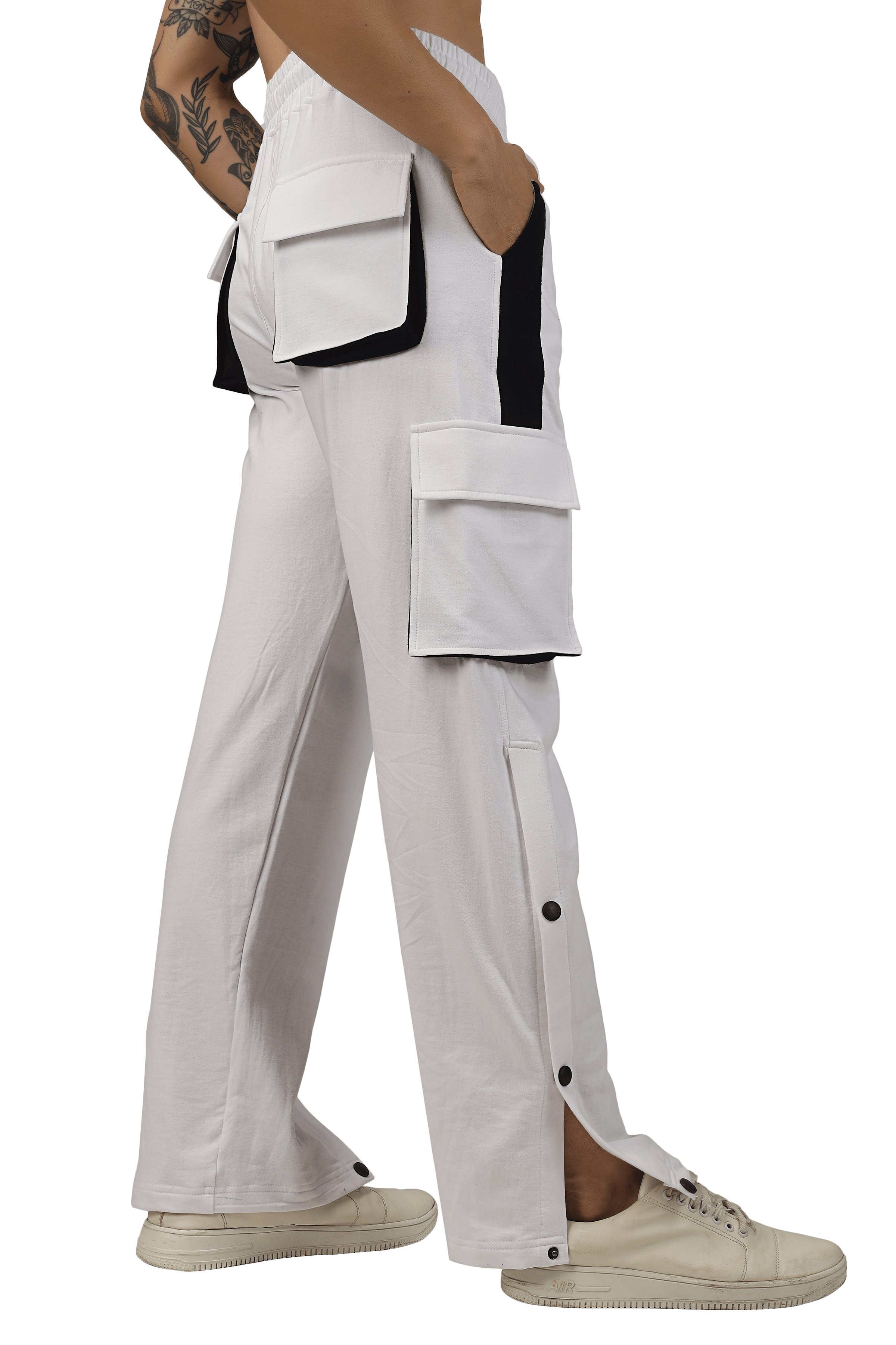 Side view of BRACKET Cargo Pant in white with black highlights, featuring multiple pockets and button details, worn with sneakers.