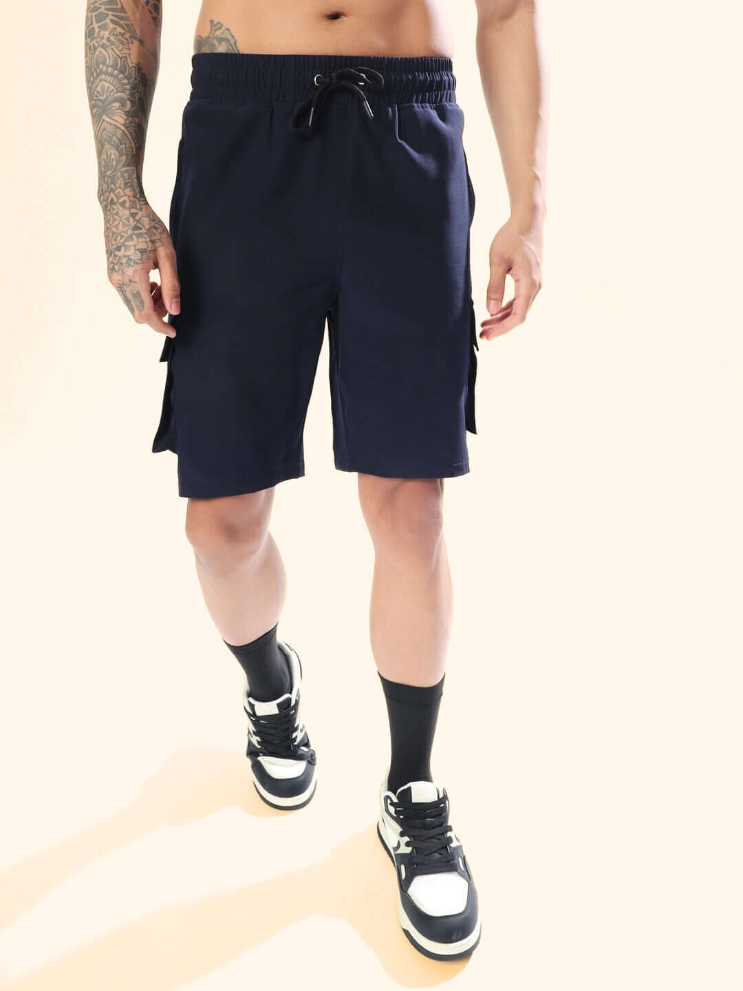 Man wearing navy blue Brawny cargo shorts, showcasing custom fit option and stylish design with sneakers.